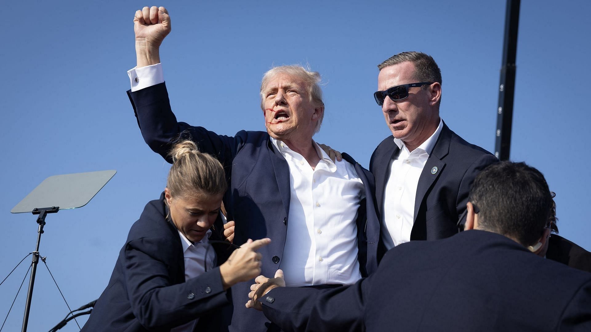 Republican Donald Trump defiantly pumps his fist after being shot and rushed offstage during a rally on July 13, 2024, in Butler, Pennsylvania (Image via Getty/Anna Moneymaker)