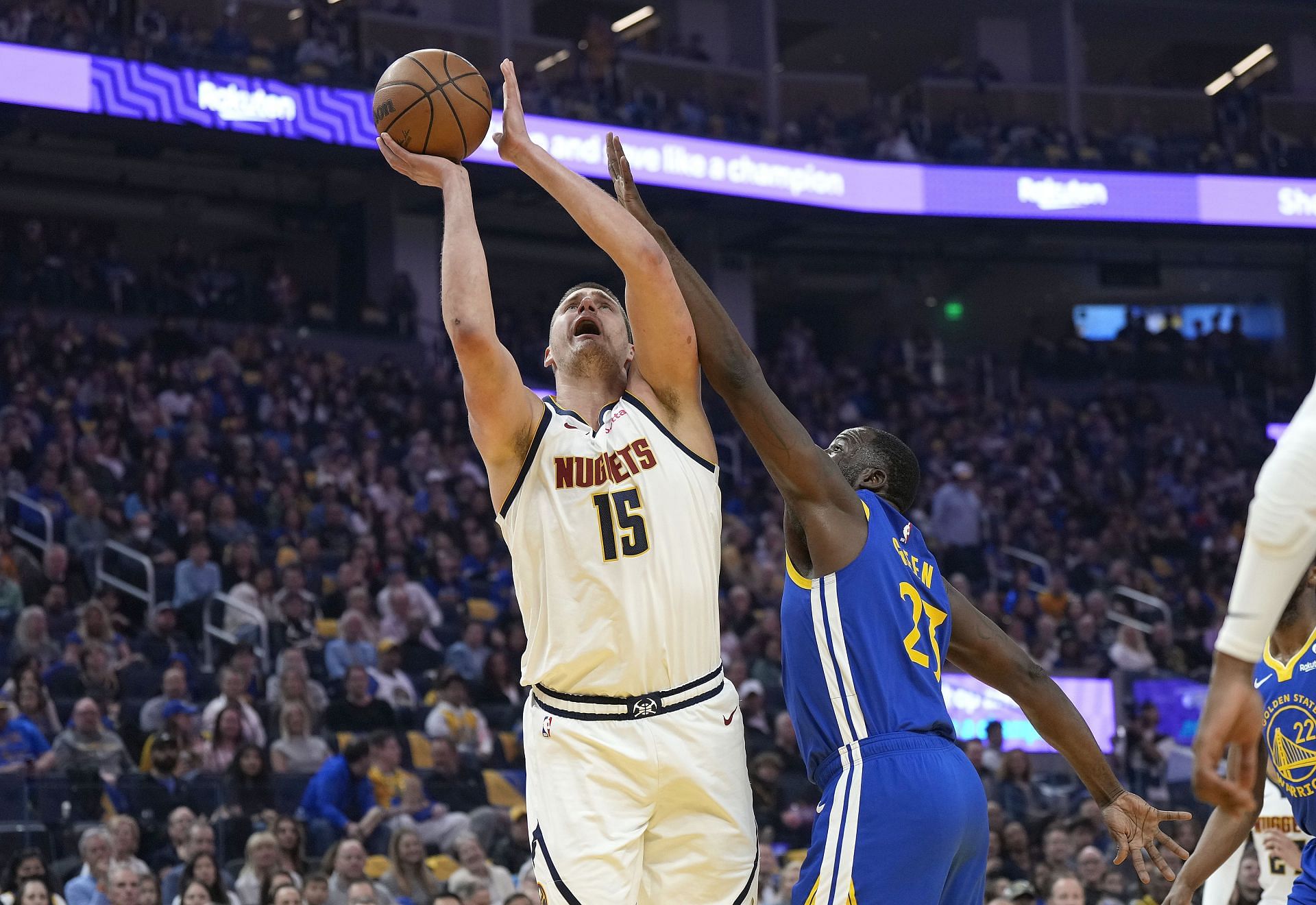 Nikola Jokic and Draymond Green facing off at the basket - Source: Getty