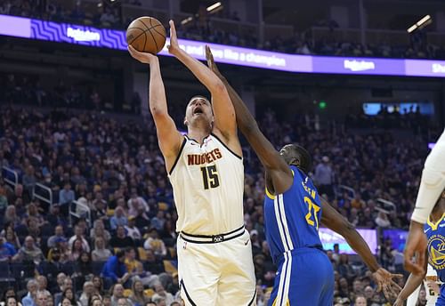 Nikola Jokic and Draymond Green facing off at the basket - Source: Getty