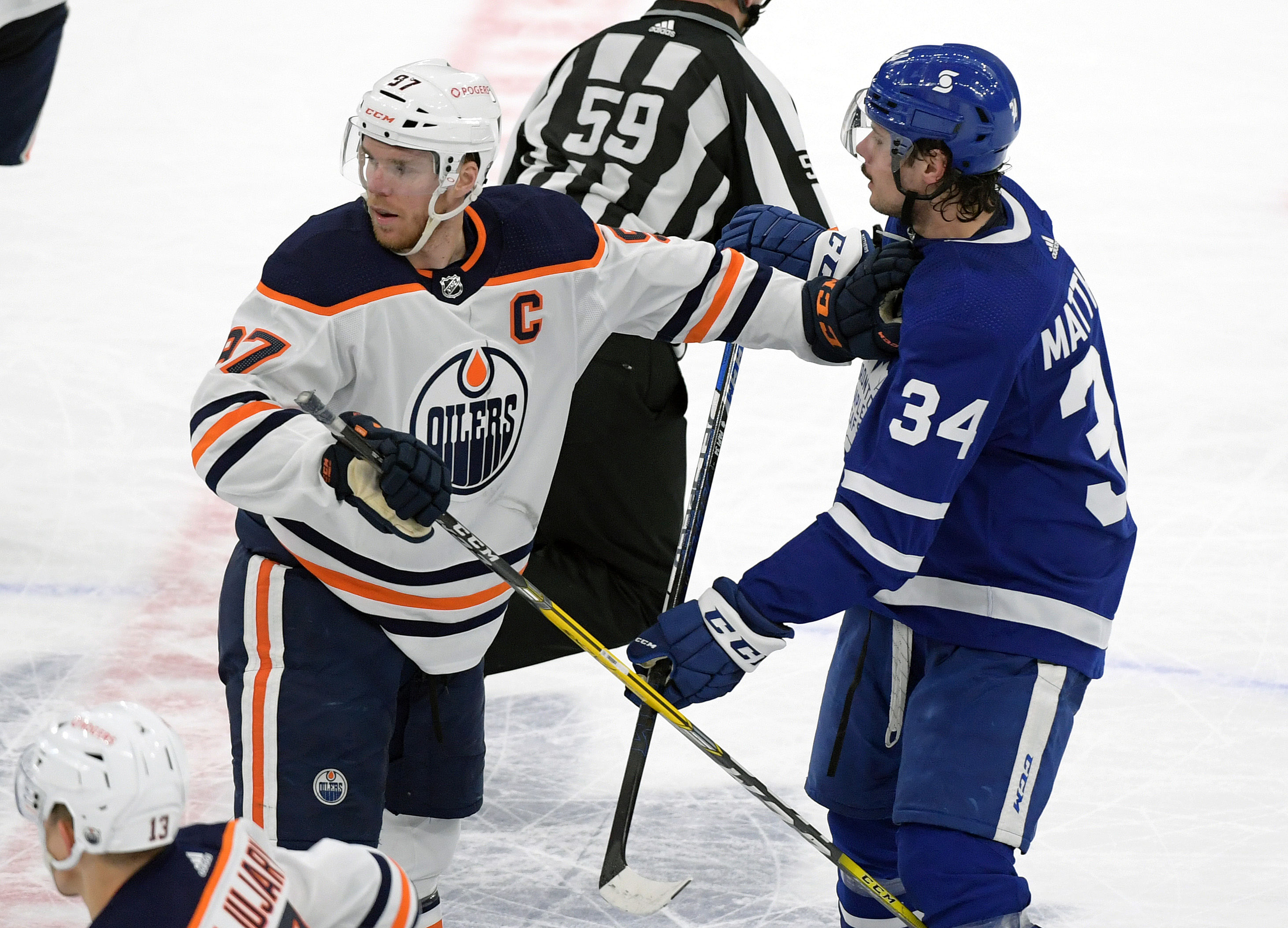 Mar 29, 2021; Toronto, Ontario, CAN; Edmonton Oilers forward Connor McDavid (97) and Toronto Maple Leafs forward Auston Matthews (24) battle for position in the third period - Source: Imagn