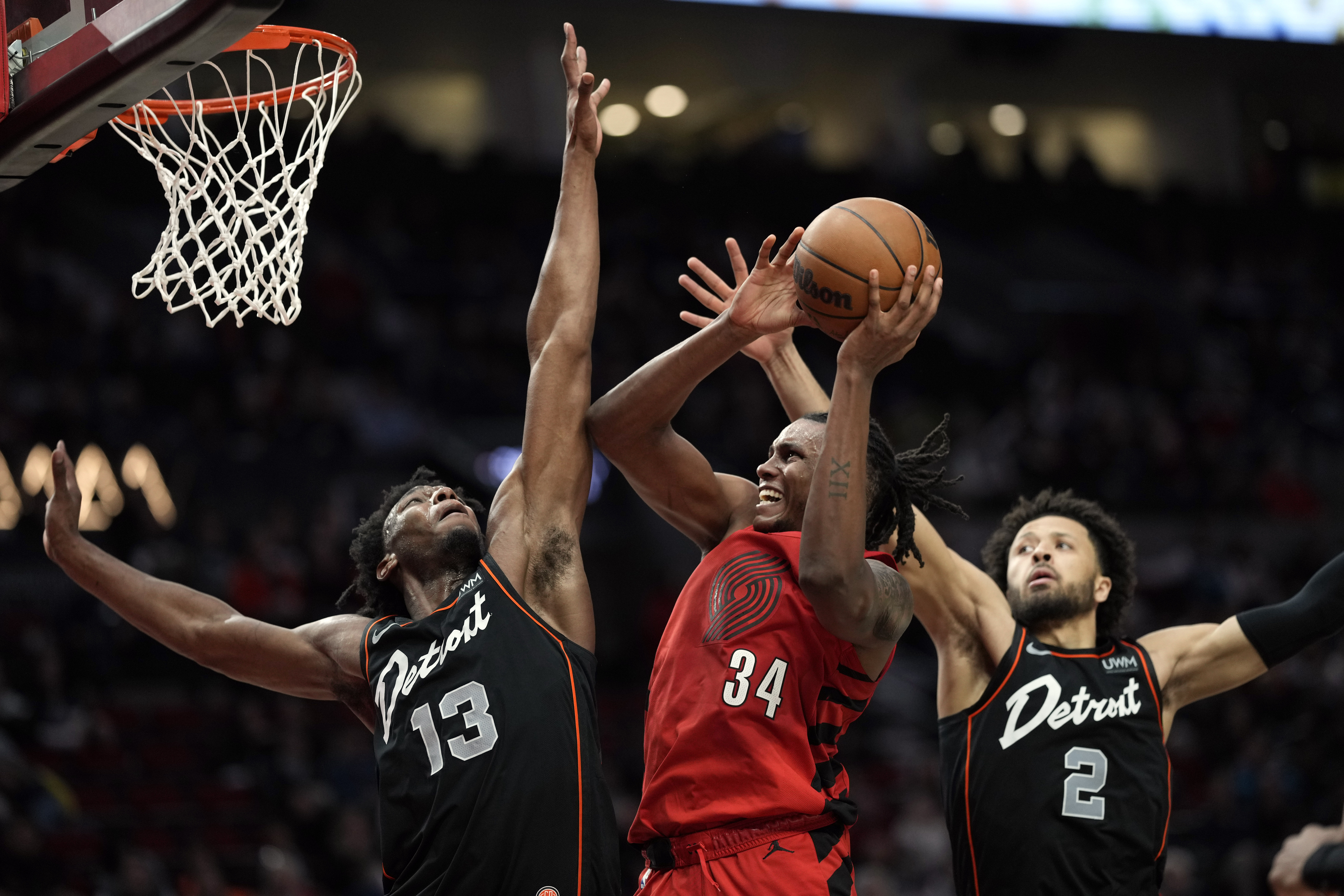 Feb 8, 2024; Portland, Oregon, USA; Portland Trail Blazers forward Jabari Walker (34) shoots the ball against Detroit Pistons center James Wiseman (13) and point guard Cade Cunningham (2) during the second half at Moda Center. Mandatory Credit: Soobum Im-Imagn Images - Source: Imagn