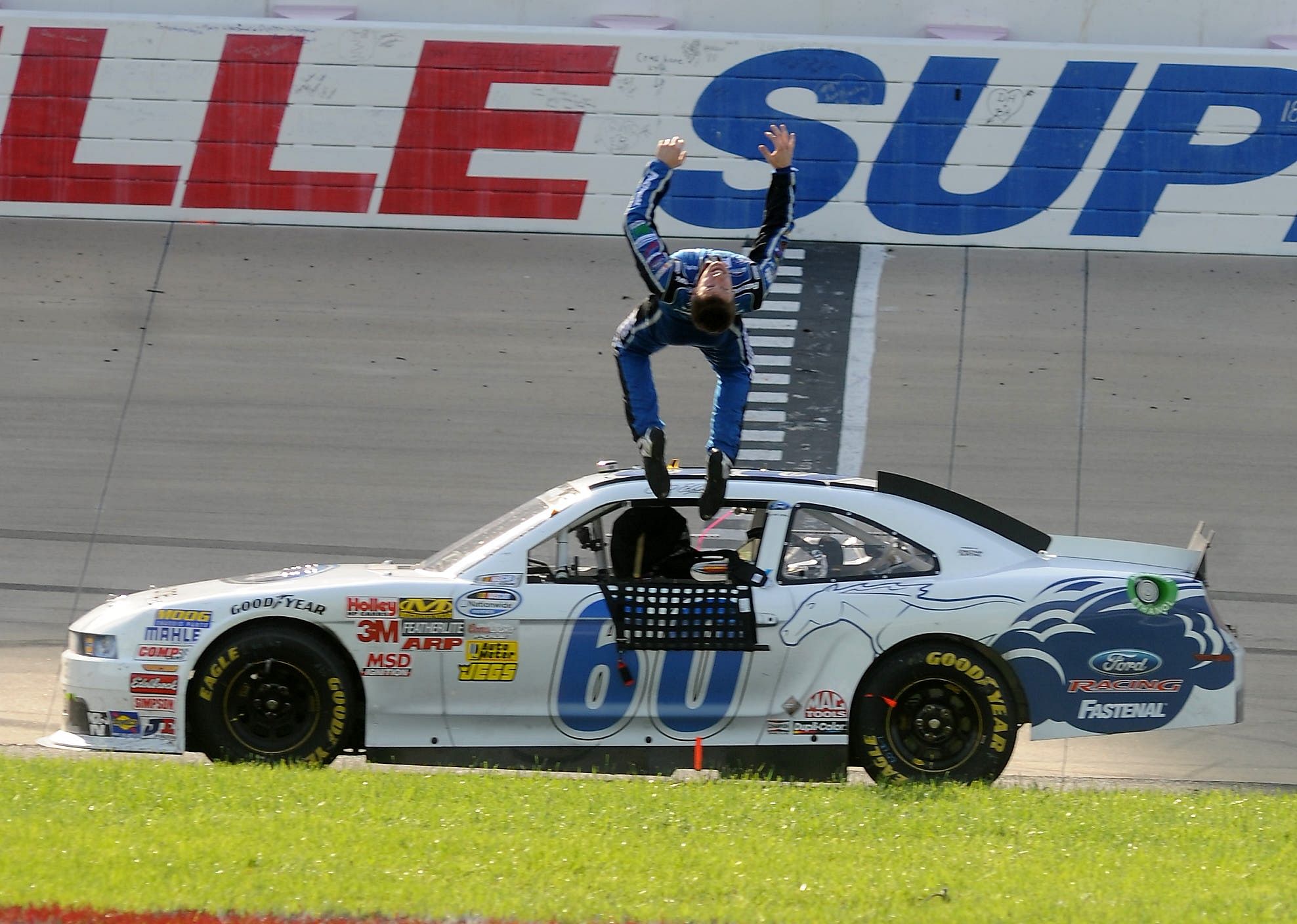 Carl Edwards does his signature backflip after winning the NASCAR Nationwide Series race at Nashville Superspeedway - Source: Imagn