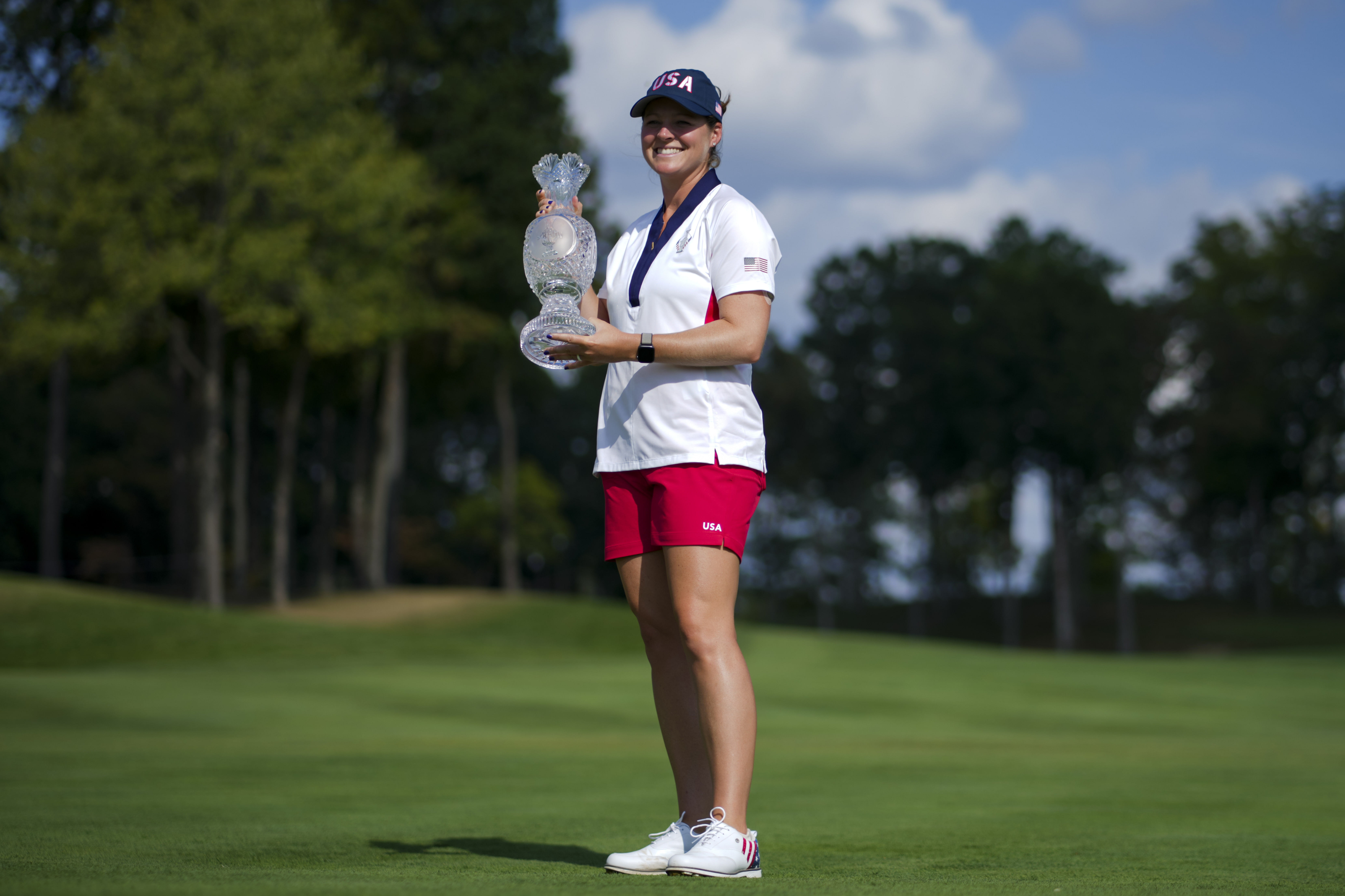 Ally Ewing of Team USA poses for a photo with the Solheim Cup trophy after defeating Team Europe (Image Source: Imagn)