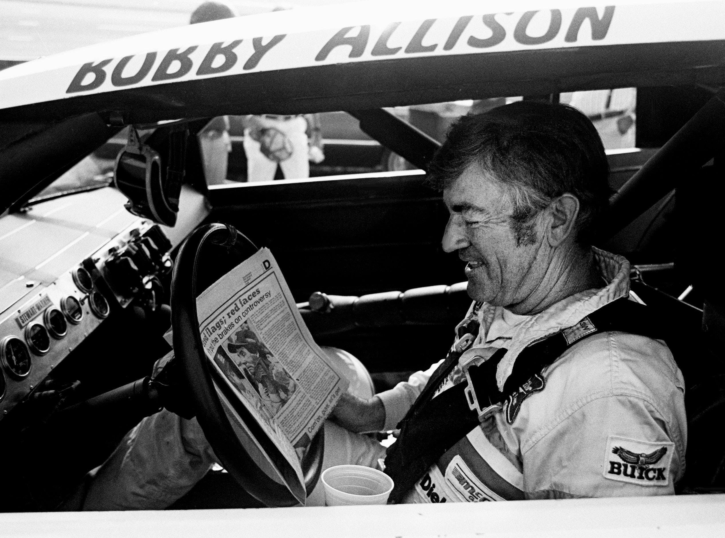 Bobby Allison checks out the newspaper during qualifying trials for the Nashville Pepsi 420 NASCAR Grand National race at Nashville International Raceway on July 13, 1984 - Source: Imagn