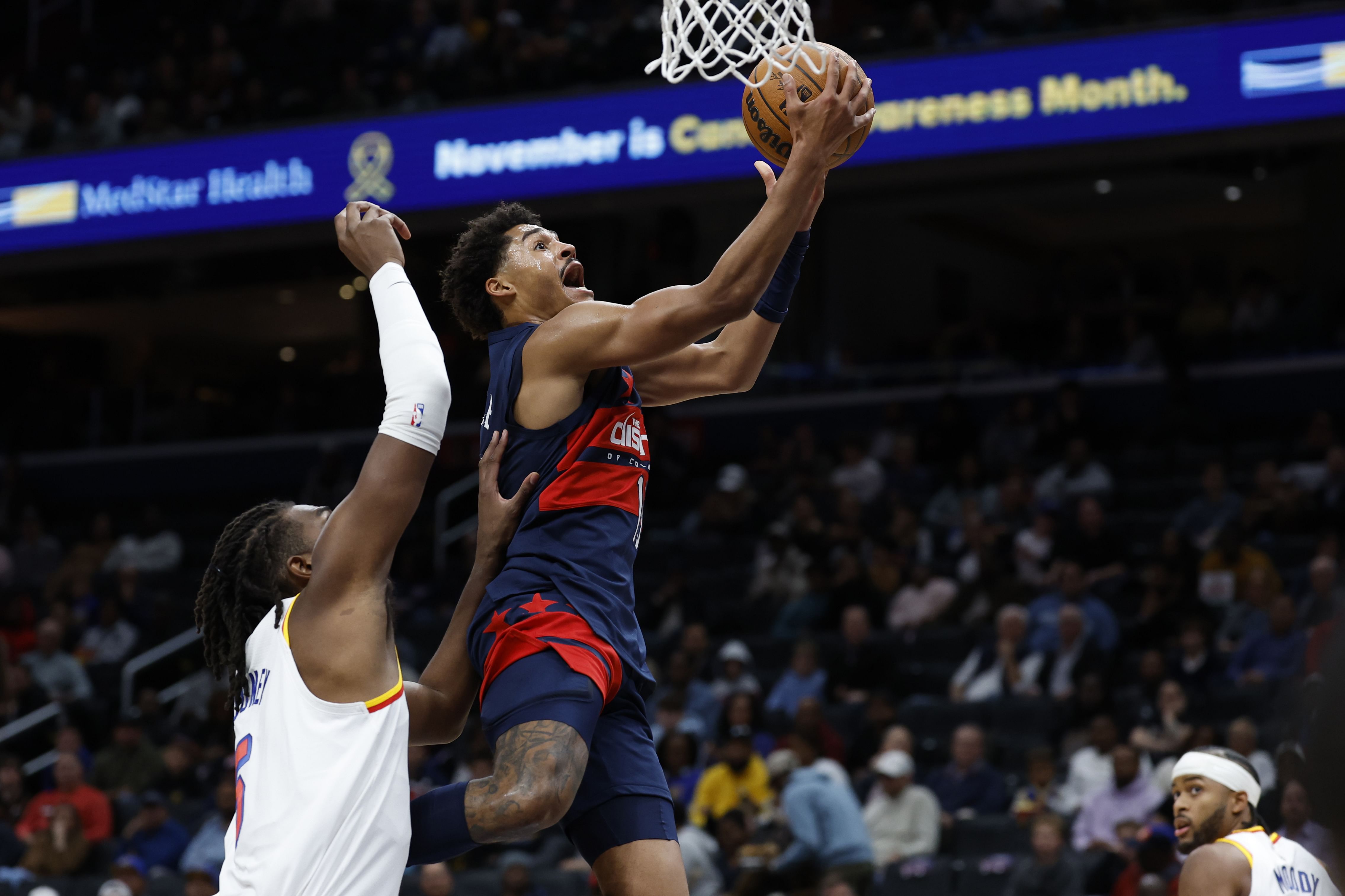 Washington Wizards guard Jordan Poole shoots the ball as Golden State Warriors forward Kevon Looney defends at Capital One Arena. Photo Credit: Imagn