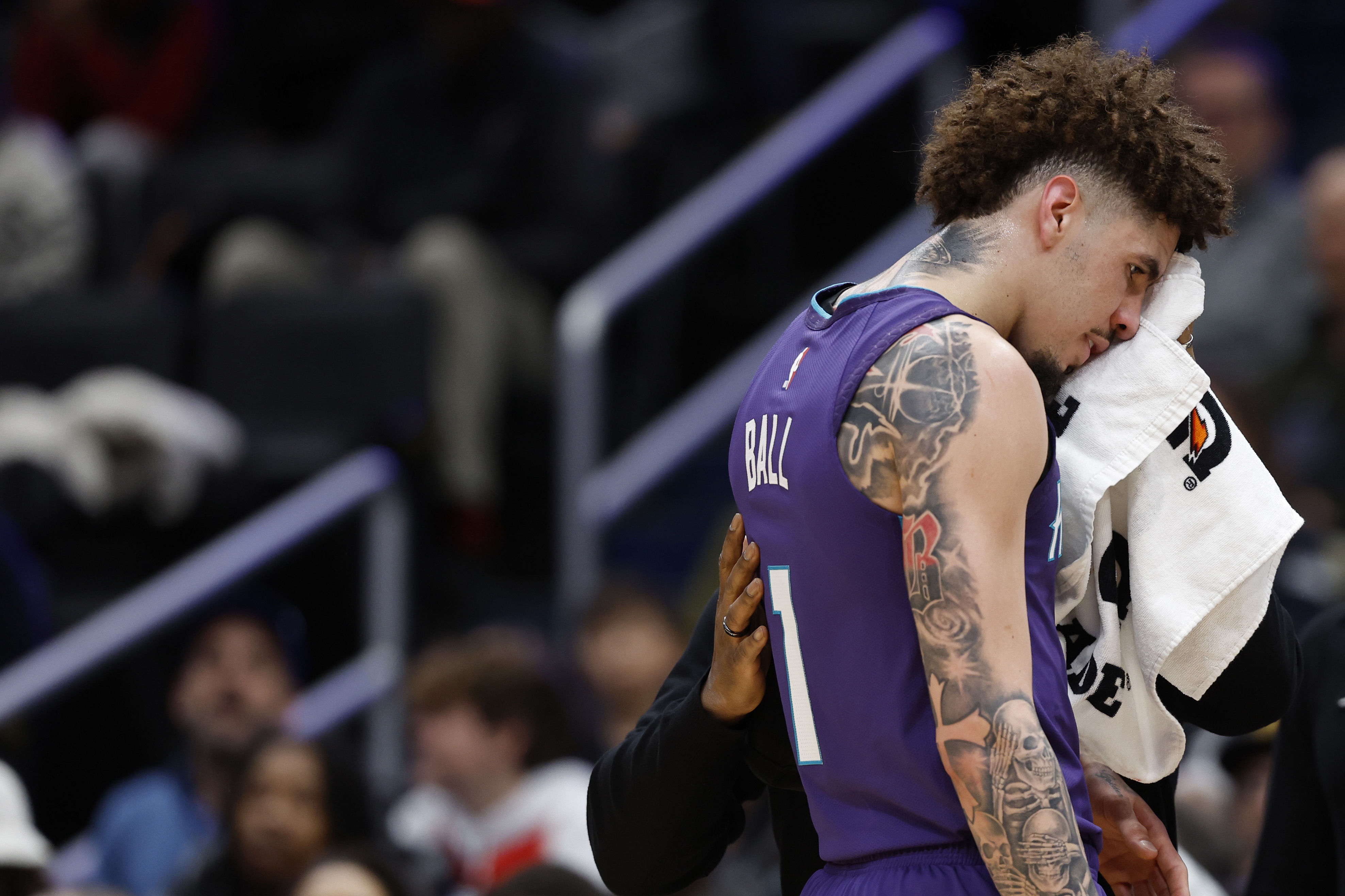 Dec 19, 2024; Washington, District of Columbia, USA; Charlotte Hornets guard LaMelo Ball (1) is assisted by a team trainer after being cut against the Washington Wizards in the second quarter at Capital One Arena. Mandatory Credit: Geoff Burke-Imagn Images - Source: Imagn