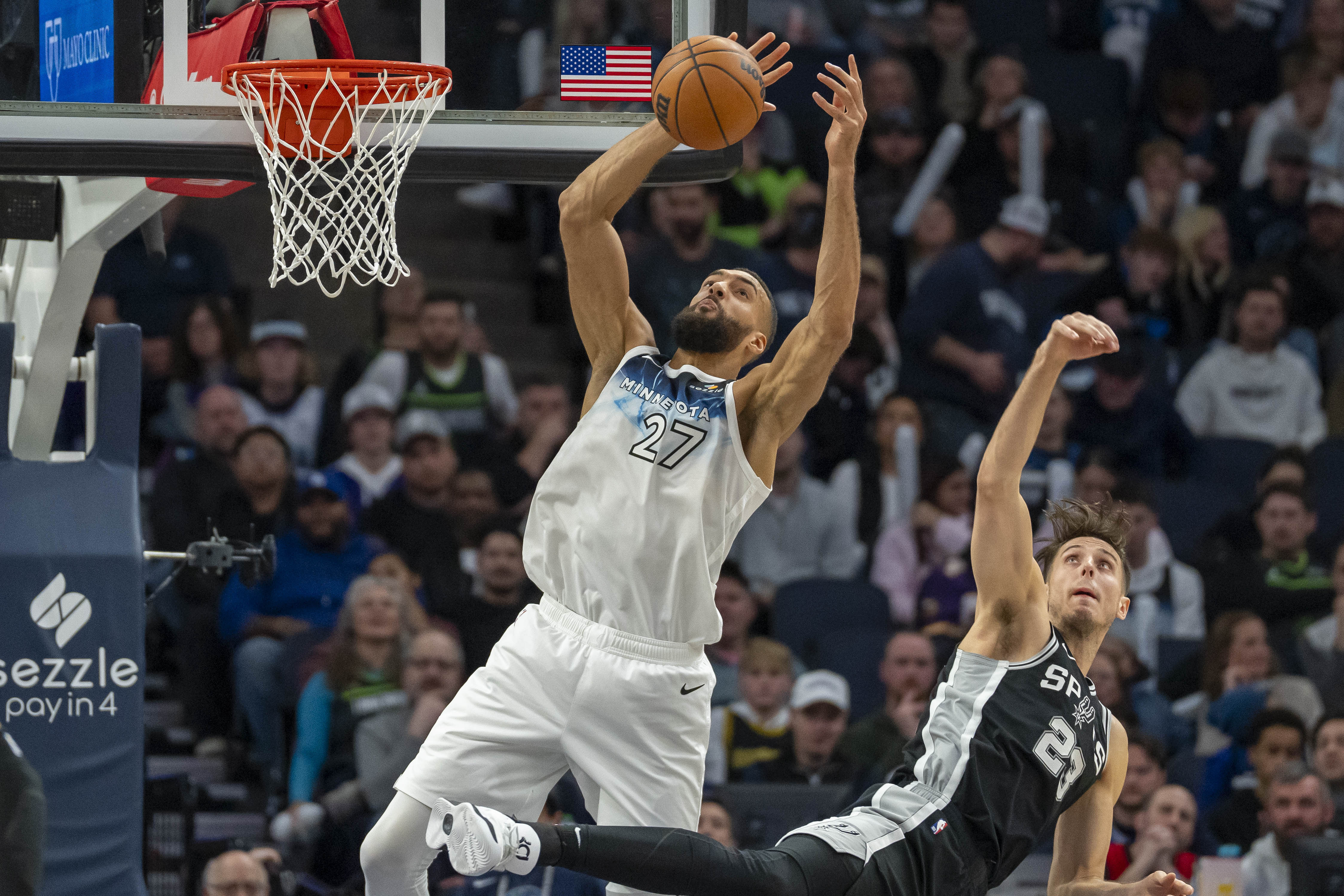 Minnesota Timberwolves center Rudy Gobert and San Antonio Spurs forward Zach Collins jump for a rebound at Target Center. Photo Credit: Imagn