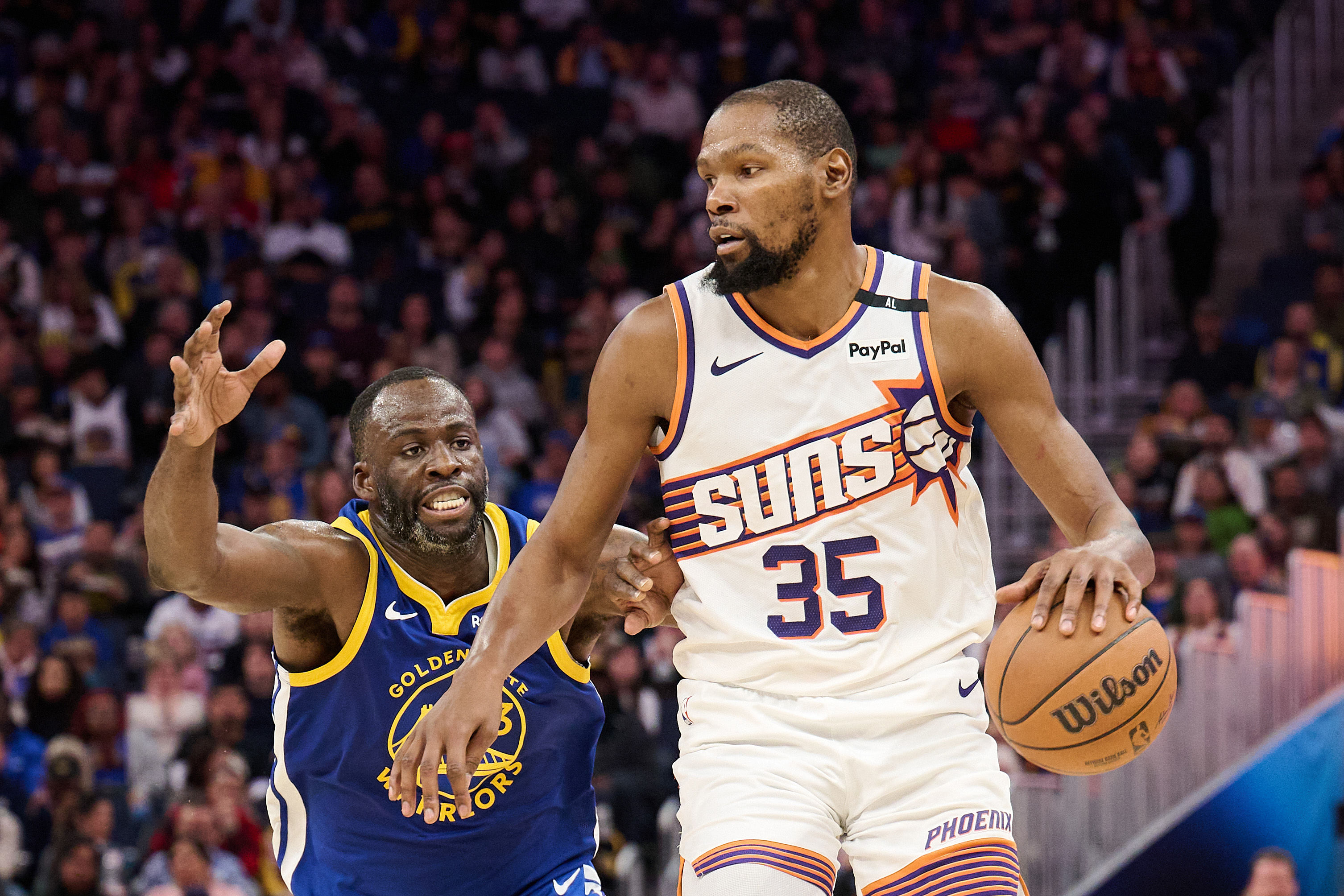 Phoenix Suns forward Kevin Durant controls the ball against Golden State Warriors forward Draymond Green at Chase Center. Photo Credit: Imagn