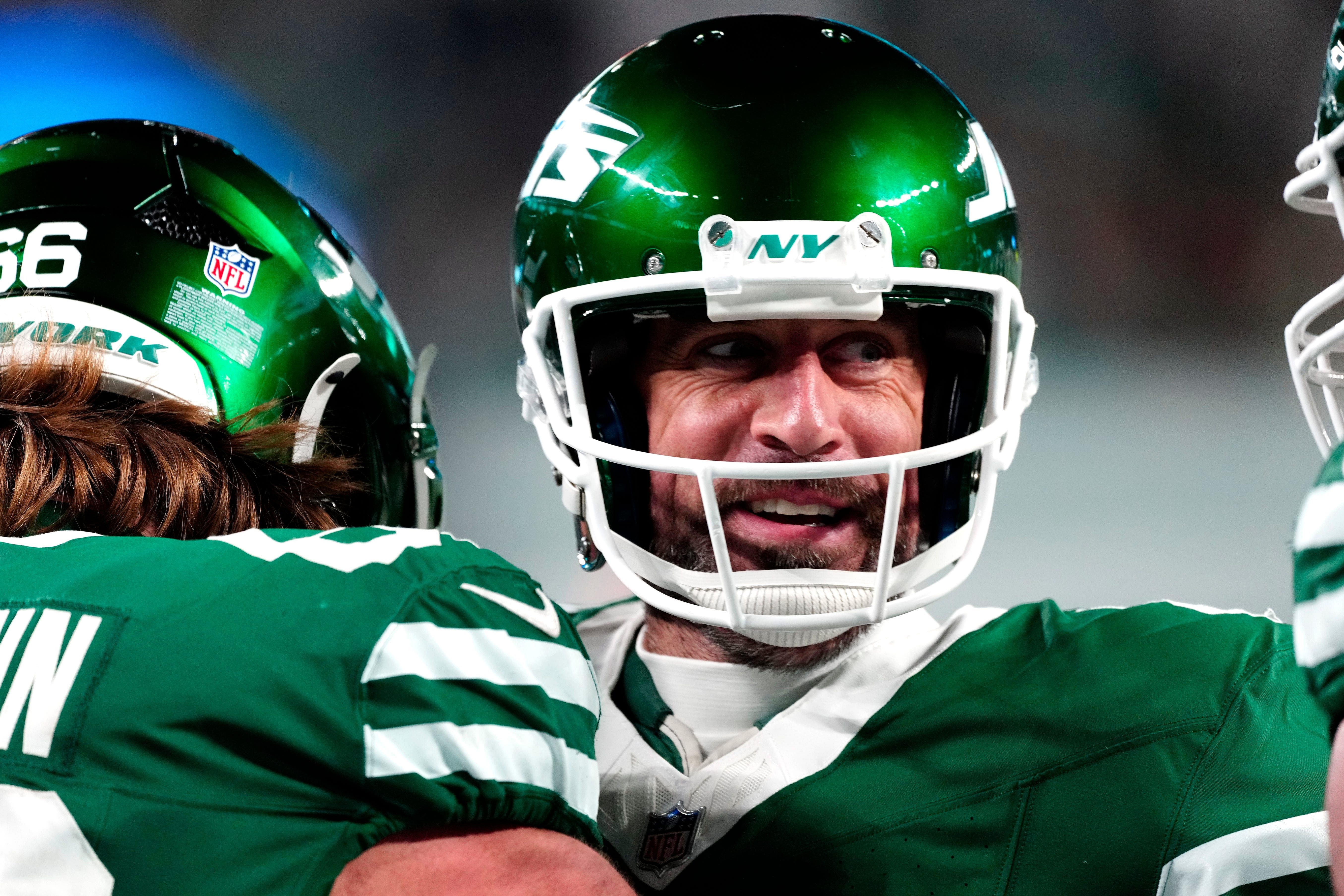 Aaron Rodgers smiling while wearing a helmet - Source: Imagn