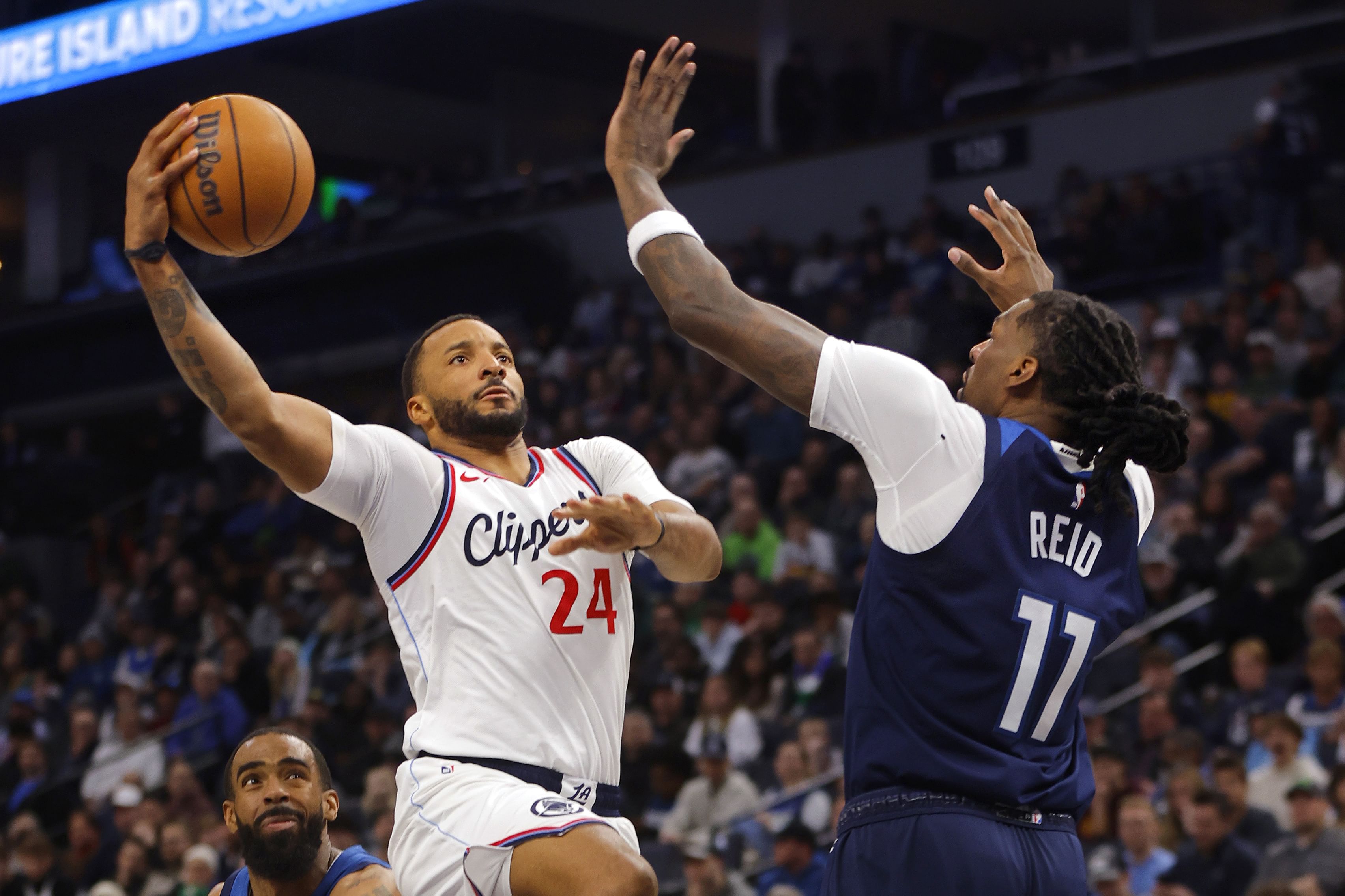 LA Clippers guard Norman Powell goes to the basket against Minnesota Timberwolves center Naz Reid at Target Center. Photo Credit: Imagn