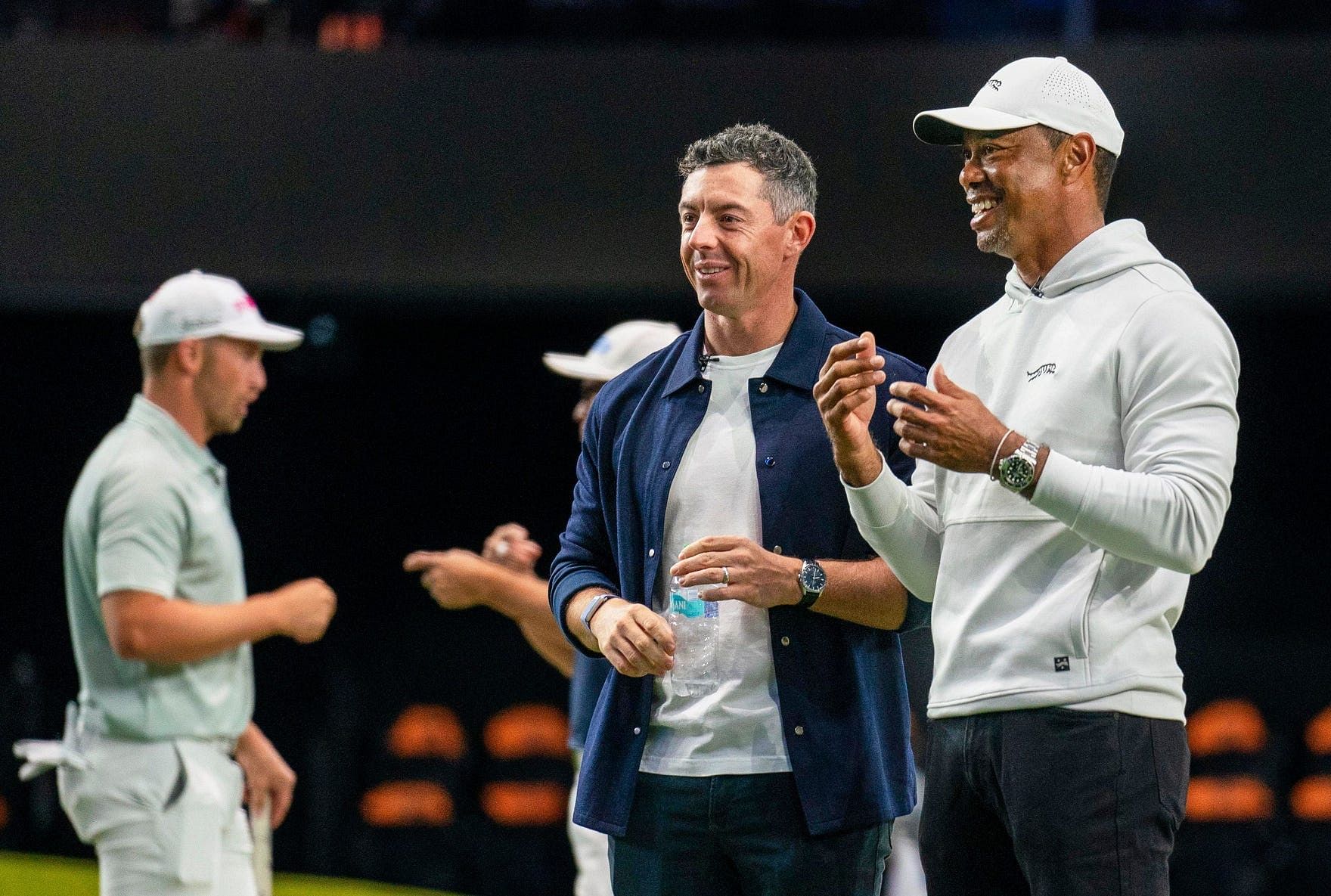 Rory McIlroy and Tiger Woods watch golfers warm up for TGL&#039;s inaugural match at SoFi Center in Palm Beach Gardens, Florida. - Source: Imagn