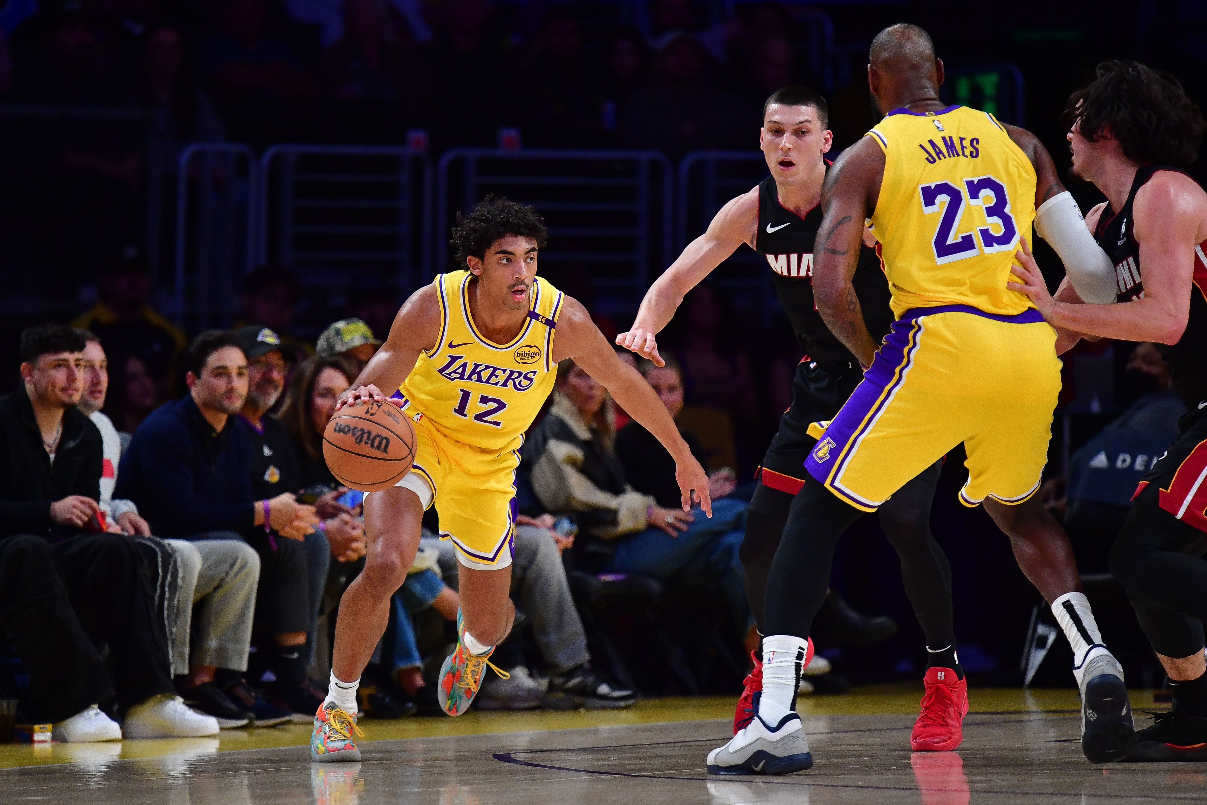 Los Angeles Lakers guard Max Christie (12) moves the ball as forward LeBron James (23) provides coverage against the Miami Heat. (Credits: IMAGN)