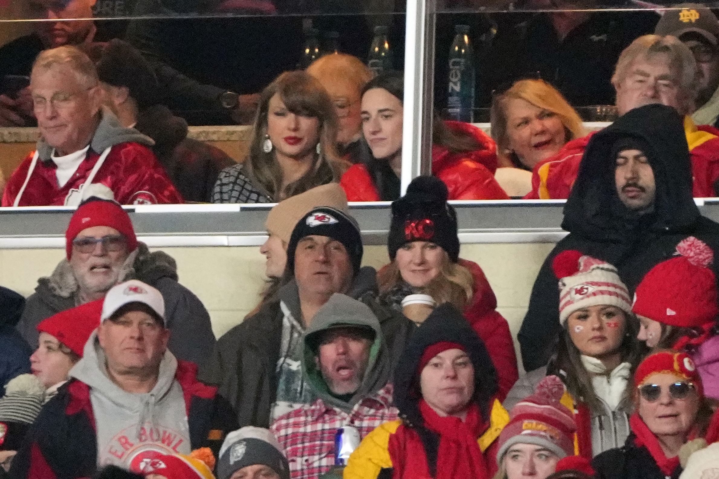 Jan 18, 2025; Kansas City, Missouri, USA; Recording artist Taylor Swift (upper middle) sits with Indiana Fever guard Caitlin Clark (upper right) during the fourth quarter of a 2025 AFC divisional round game between the Kansas City Chiefs and the Houston Texans at GEHA Field at Arrowhead Stadium. Mandatory Credit: Denny Medley-Imagn Images - Source: Imagn