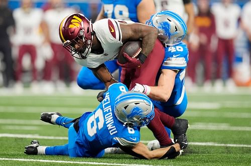 Brian Robinson Jr. gets tackled by Detroit Lions defender - Source: Imagn