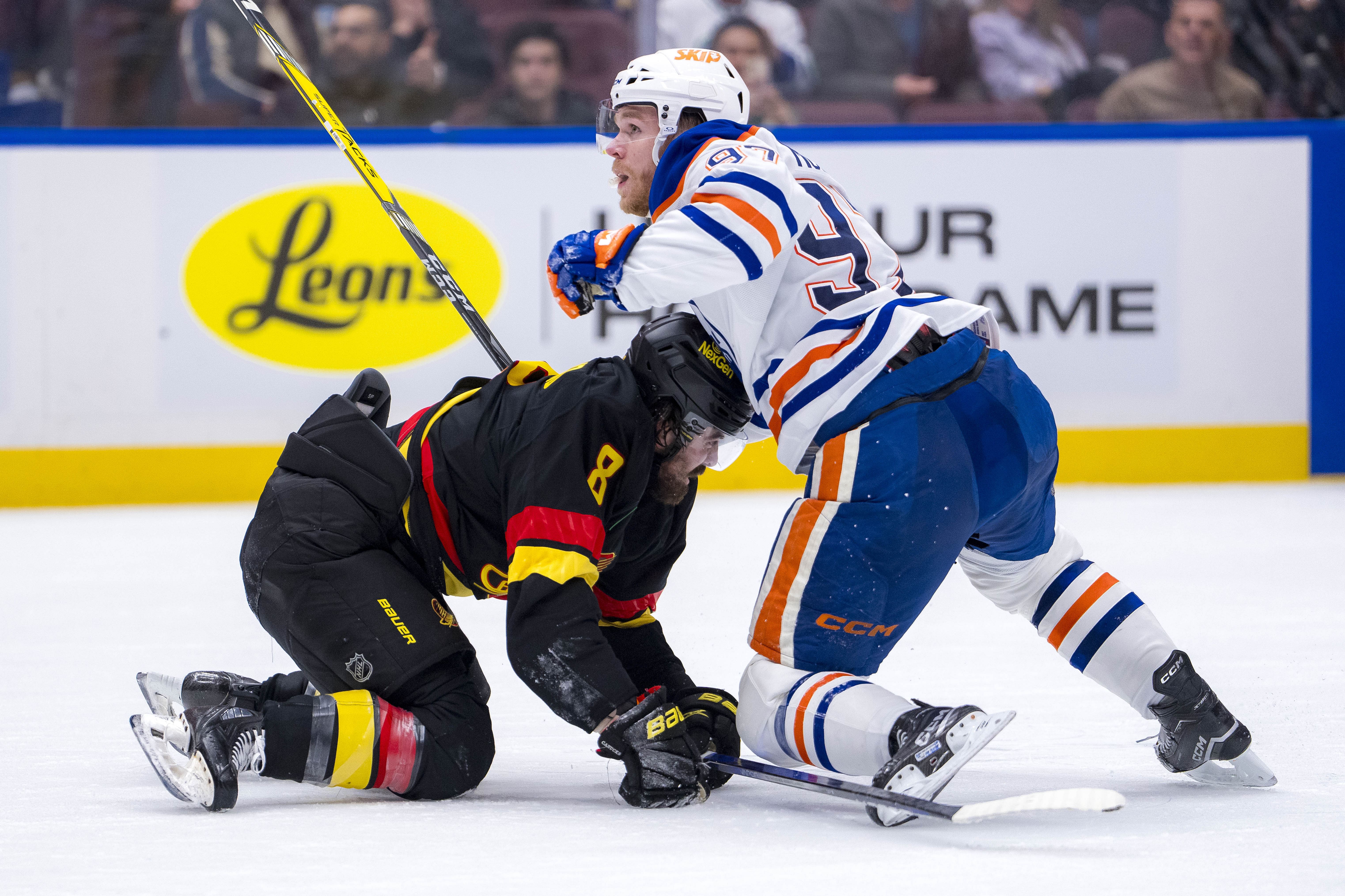 Edmonton Oilers forward Connor McDavid (97) battles with Vancouver Canucks forward Conor Garland (8). (Credits: IMAGN)