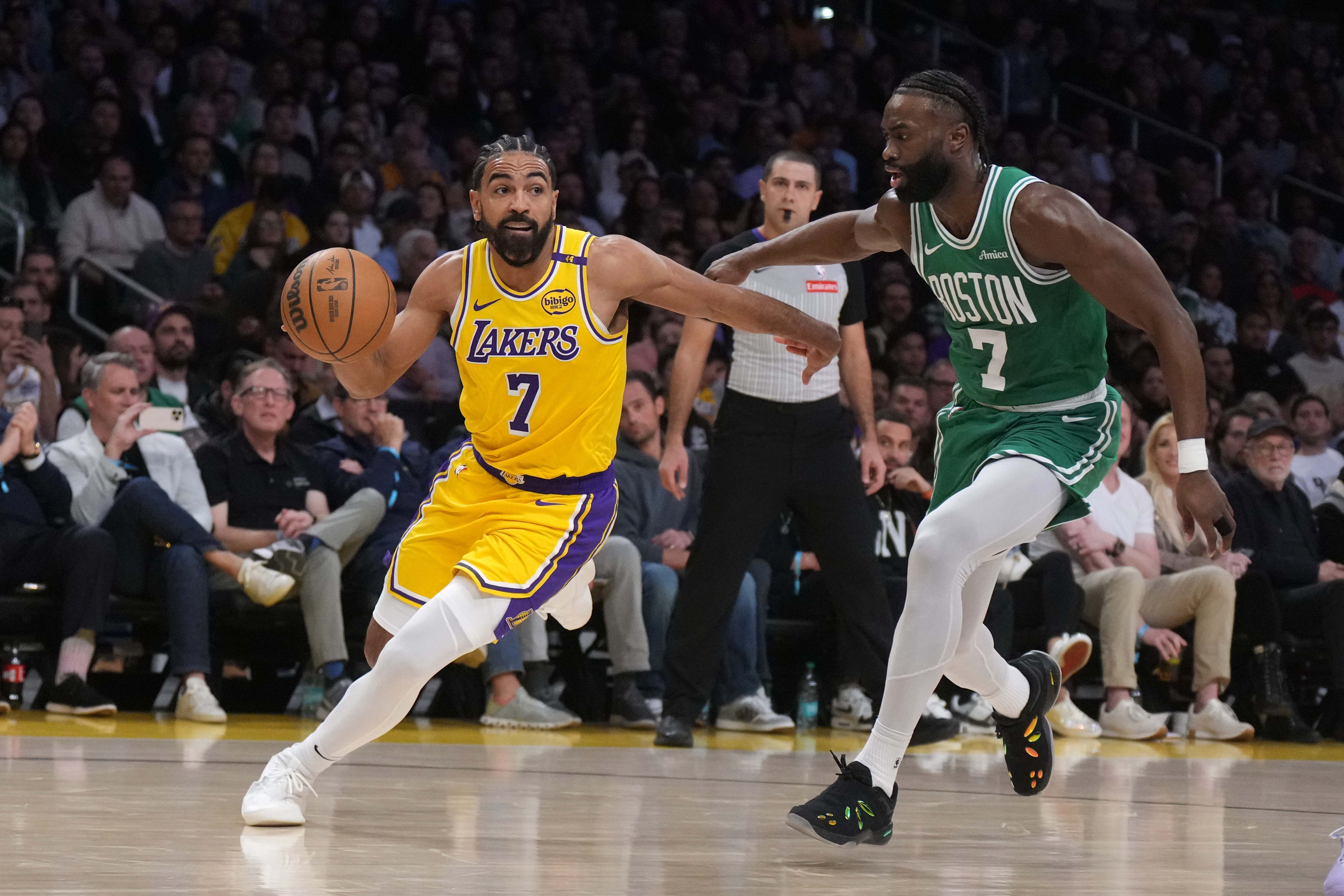 Los Angeles Lakers guard Gabe Vincent (left) dribbles the ball against Boston Celtics guard Jaylen Brown in the second half at the Crypto.com Arena. Mandatory Credit: Kirby Lee-Imagn Images