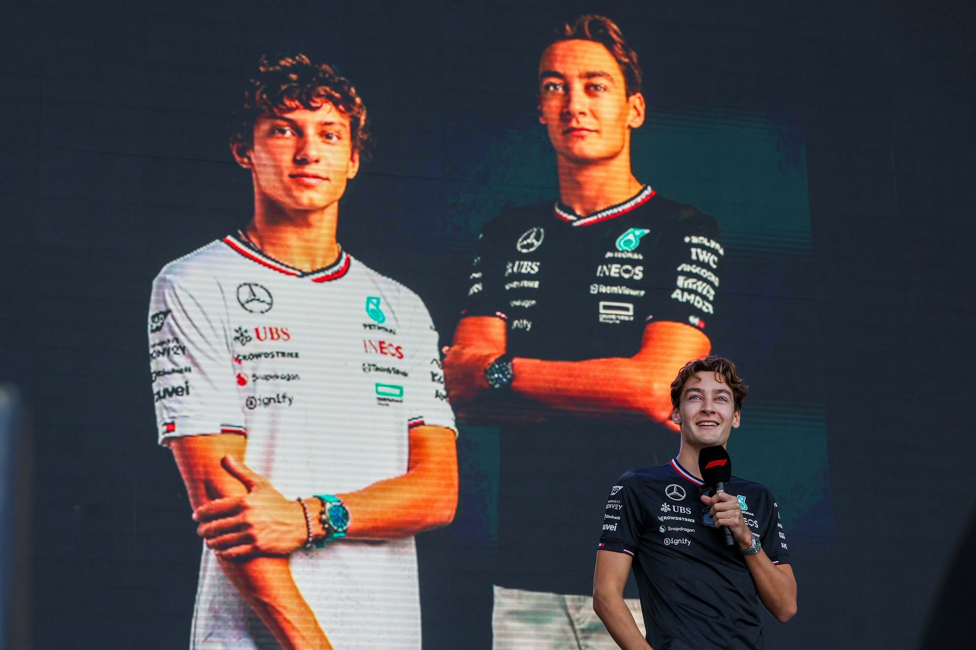 George Russell speaks at the Fan Forum with a photo of himself and future teammate Andrea Kimi Antonelli before the Sprint Race of the Formula 1 Pirelli United States Grand Prix - Source: Getty