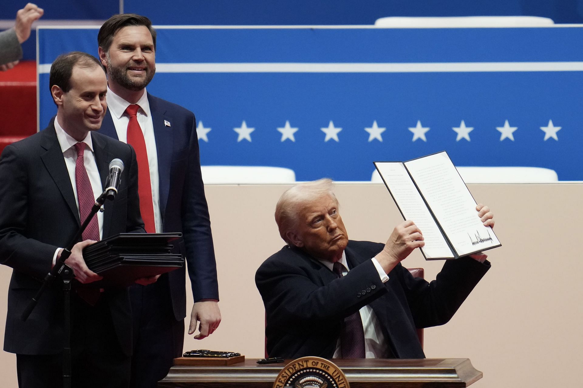 President Donald Trump holds up an executive order after signing it at Capital One Arena on January 20, 2025 in Washington, DC. (Image via Getty)