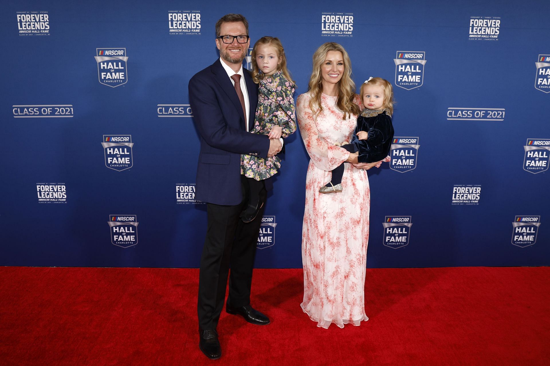 NASCAR Hall of Fame inductee Dale Earnhardt Jr., his wife Amy Earnhardt, and their daughters Isla (L) and Nicole, pose on the red carpet - Source: Getty Images