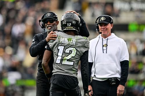 Travis Hunter #12 of the Colorado Buffaloes celebrates with head coach Deion Sanders after scoring a fourth quarter touchdown against the Utah Utes  - Source: Getty