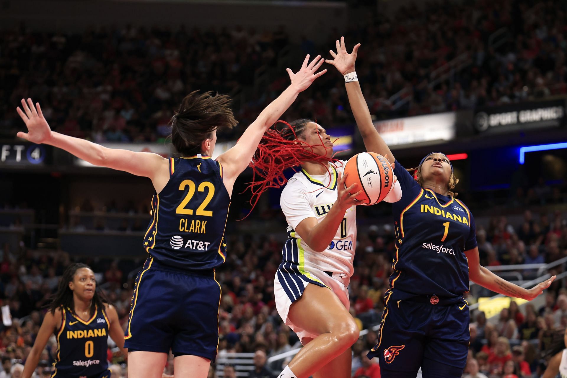 Forward Satou Sabally #0 of the Dallas Wings takes a shot against Caitlin Clark #22 and NaLyssa Smith #1 of the Indiana Fever during a WNBA game. (Credits: Getty)