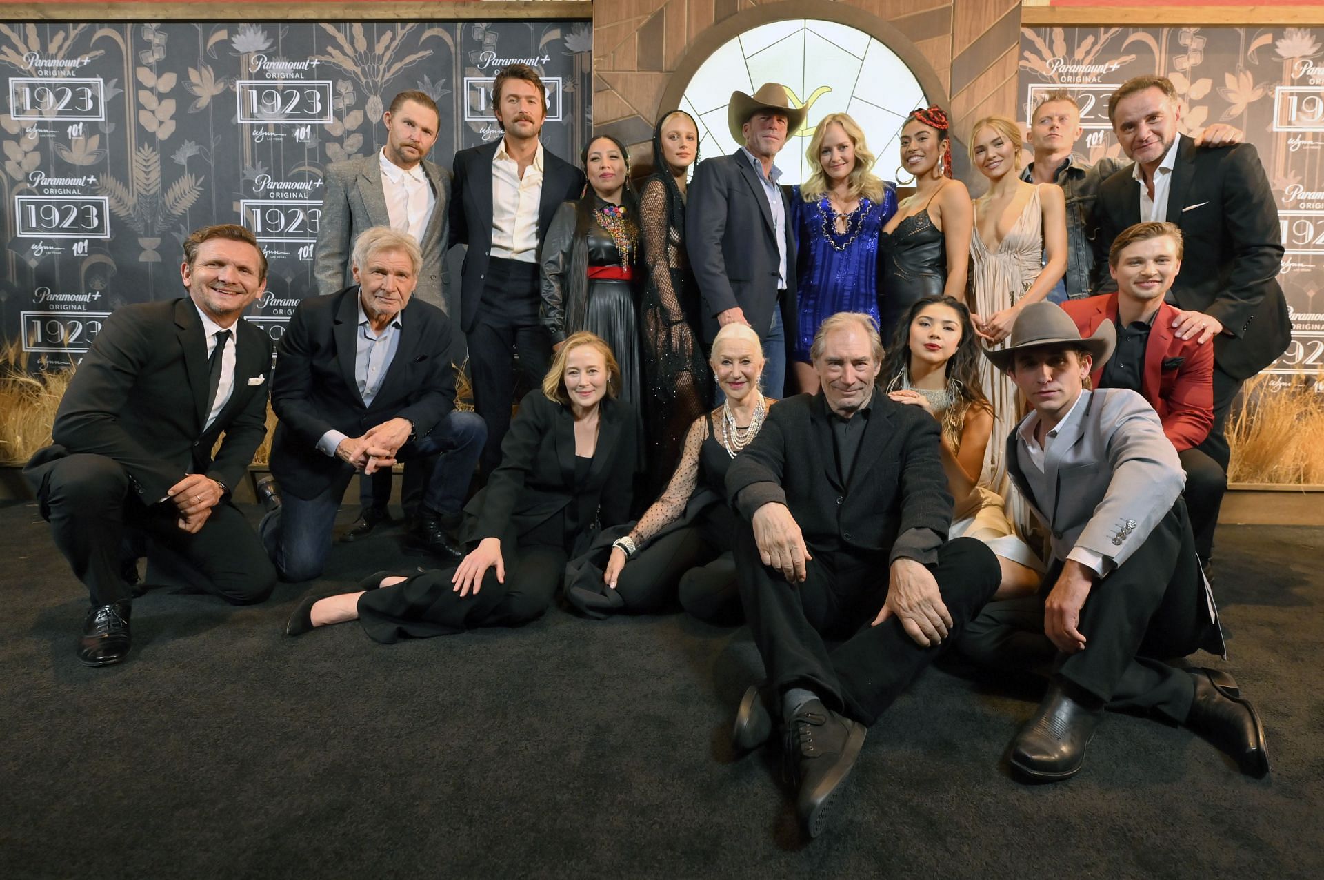 (Front Row L-R) Sebastian Roch&eacute;, Harrison Ford, Jennifer Ehle, Helen Mirren, Timothy Dalton, Leenah Robinson, Caleb Martin and Darren Mann (back row L-R) Brian Geraghty, Brandon Sklenar, Amelia Rico, Julia Schlaepfer, Taylor Sheridan, Marley Shelton, Aminah Nieves, Michelle Randolph, James Badge Dale and Tim DeKay attend the &quot;1923&quot; Las Vegas premiere screening the Encore Theater at Wynn Las Vegas on December 03, 2022 in Las Vegas, Nevada. (Image via Getty)