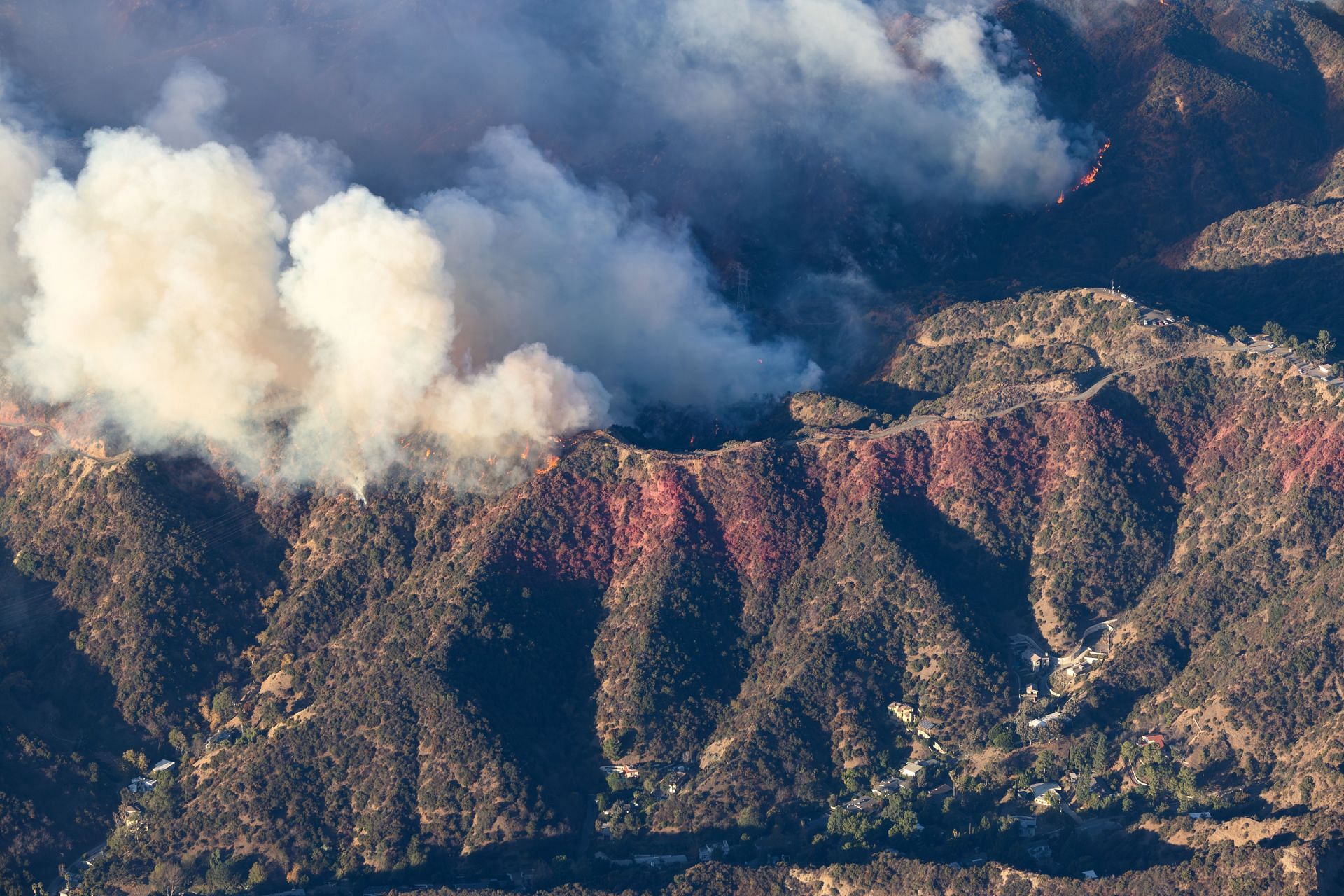 Helicopter aerial view of the Palisades fire burning above homes on Mandeville Canyon Road, Los Angeles (Image Source: Getty)