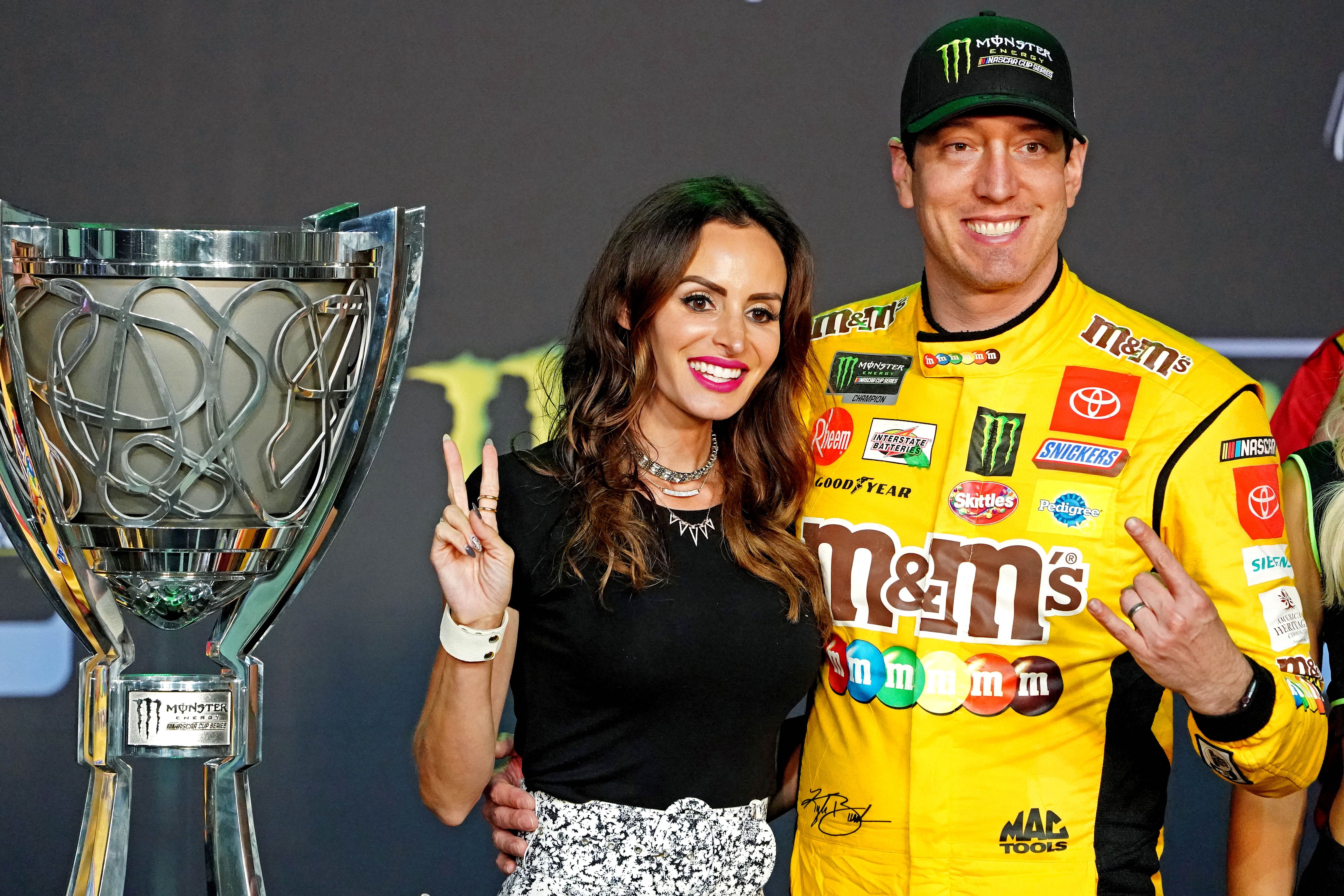 NASCAR Cup Series driver Kyle Busch (18) celebrates after winning the NASCAR Series Cup Championship with his wife Samantha Busch after the Ford EcoBoost 400 at Homestead-Miami Speedway. Mandatory Credit: John David Mercer-Imagn Images