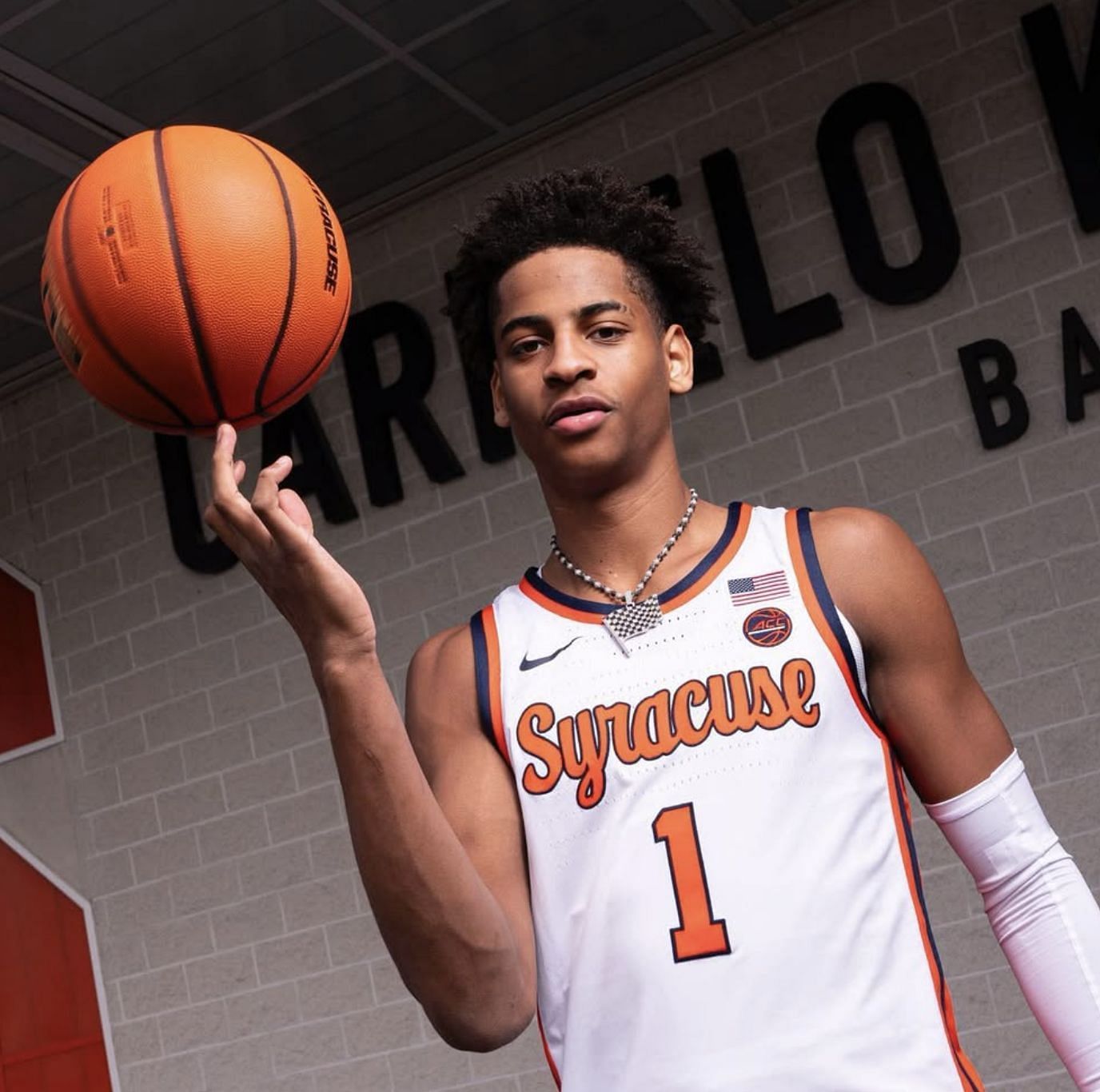 Kiyan Anthony poses in a Syracuse basketball jersey with the number 1, spinning a basketball on his hand. 