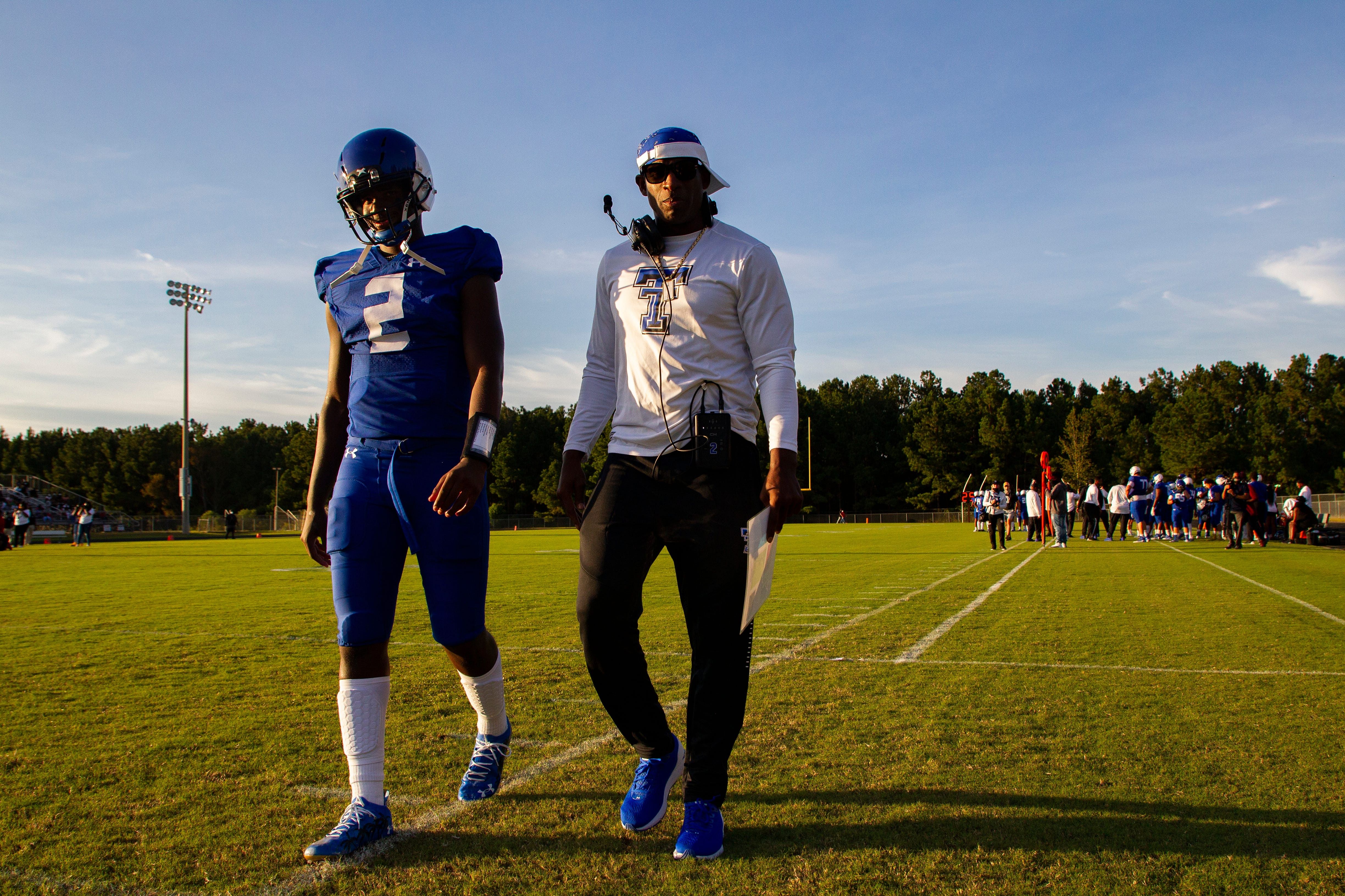 Deion Sanders walks down the sideline as he talks to his son Shedeur Sanders - Source: Imagn