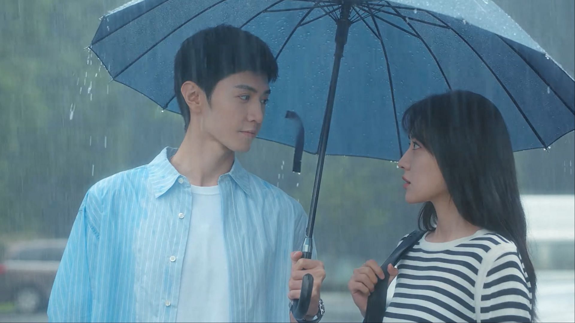 Under a shared umbrella, Chen Zheyuan as Li Zan and Liang Jie as Song Ran exchange a glance in The White Olive Tree. (Image via iQIYI)