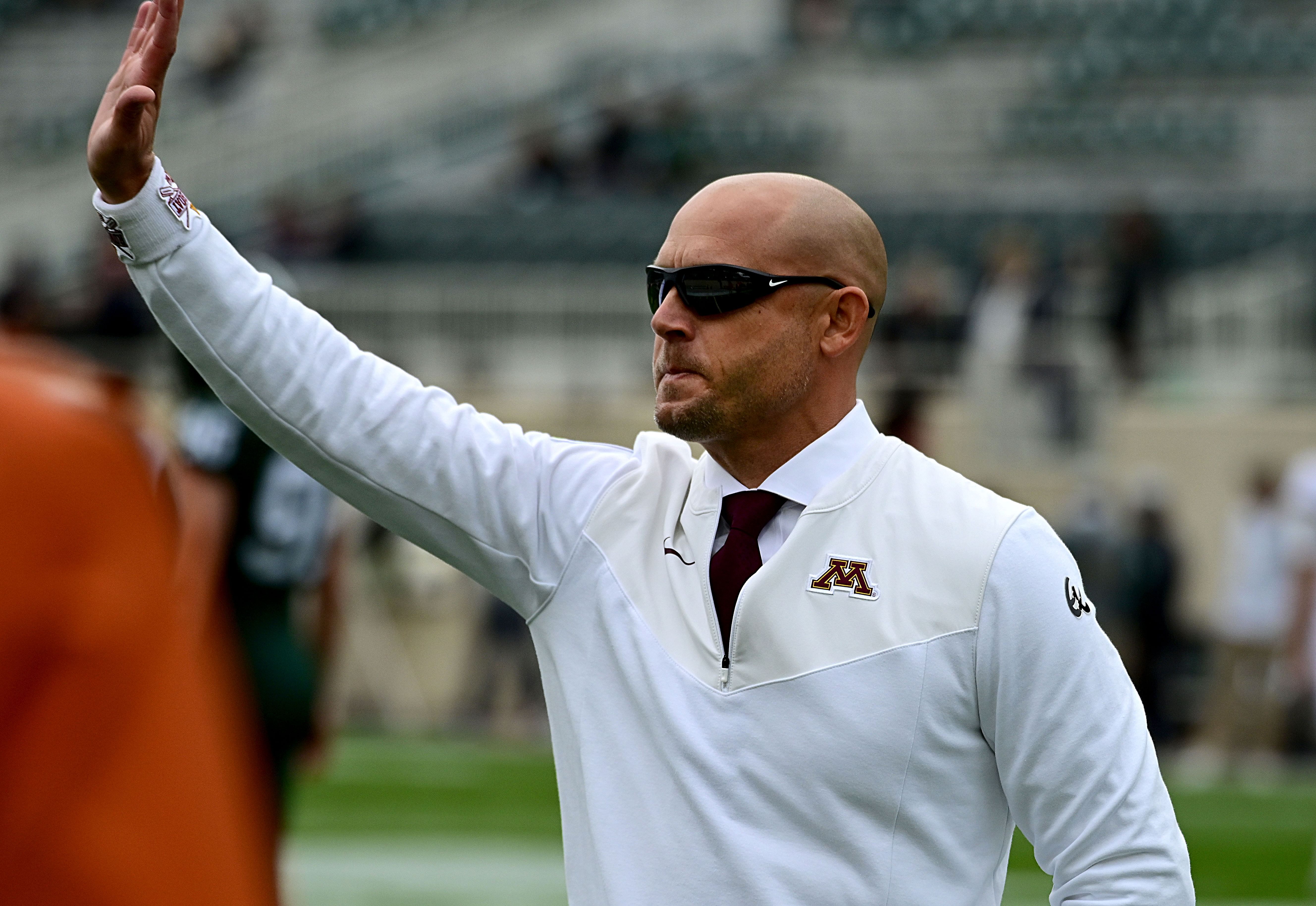 Sep 24, 2022; East Lansing, Michigan, USA; Minnesota Golden Gophers head coach PJ Fleck waves to fans at Spartan Stadium before playing MSU. Mandatory Credit: Dale Young-Imagn Images - Source: Imagn