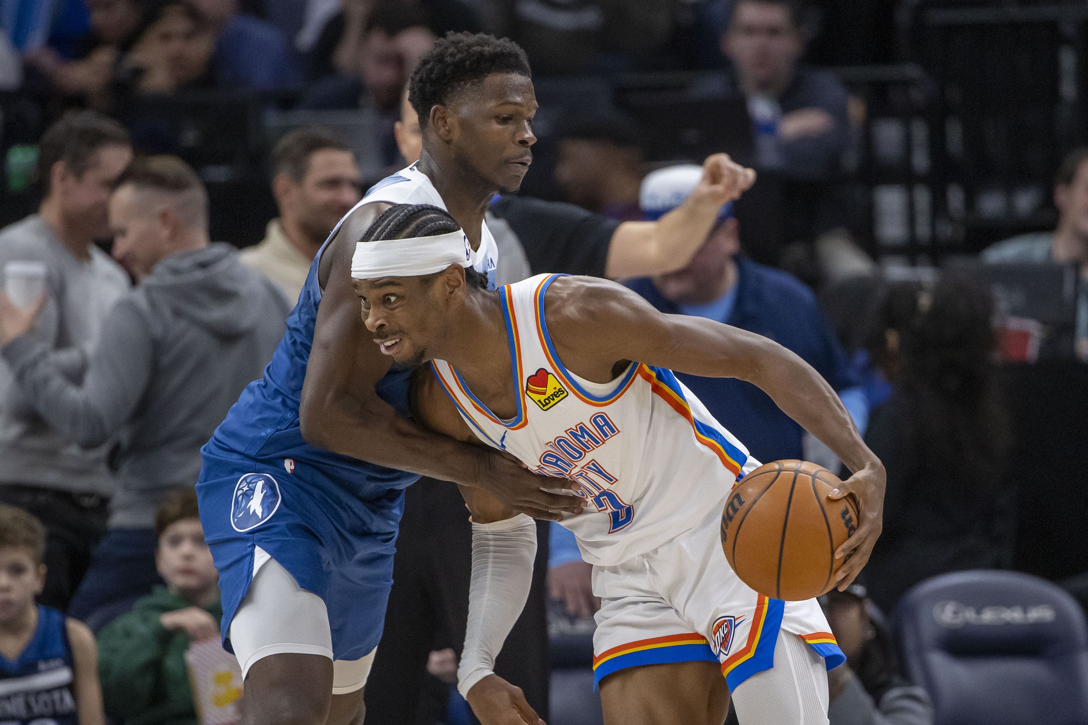 Jan 20, 2024; Minneapolis, Minnesota, USA; Oklahoma City Thunder guard Shai Gilgeous-Alexander (2) dribbles the ball past Minnesota Timberwolves guard Anthony Edwards (5) in the second half at Target Center. Mandatory Credit: Jesse Johnson-Imagn Images - Source: Imagn