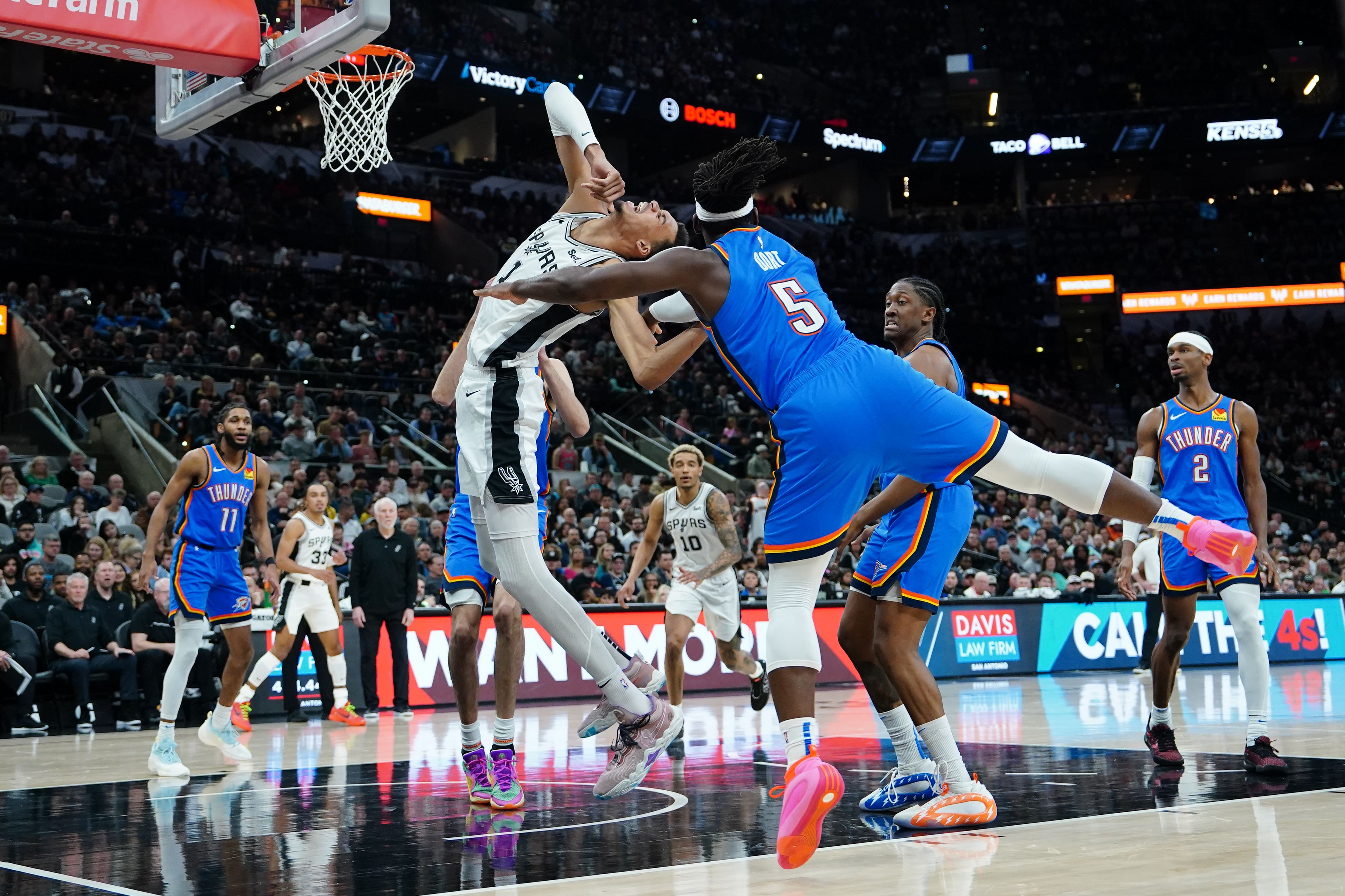 Feb 29, 2024; San Antonio, Texas, USA; Oklahoma City Thunder guard Luguentz Dort (5) could San Antonio Spurs center Victor Wembanyama (1) in the first half at Frost Bank Center.  - Source: Imagn