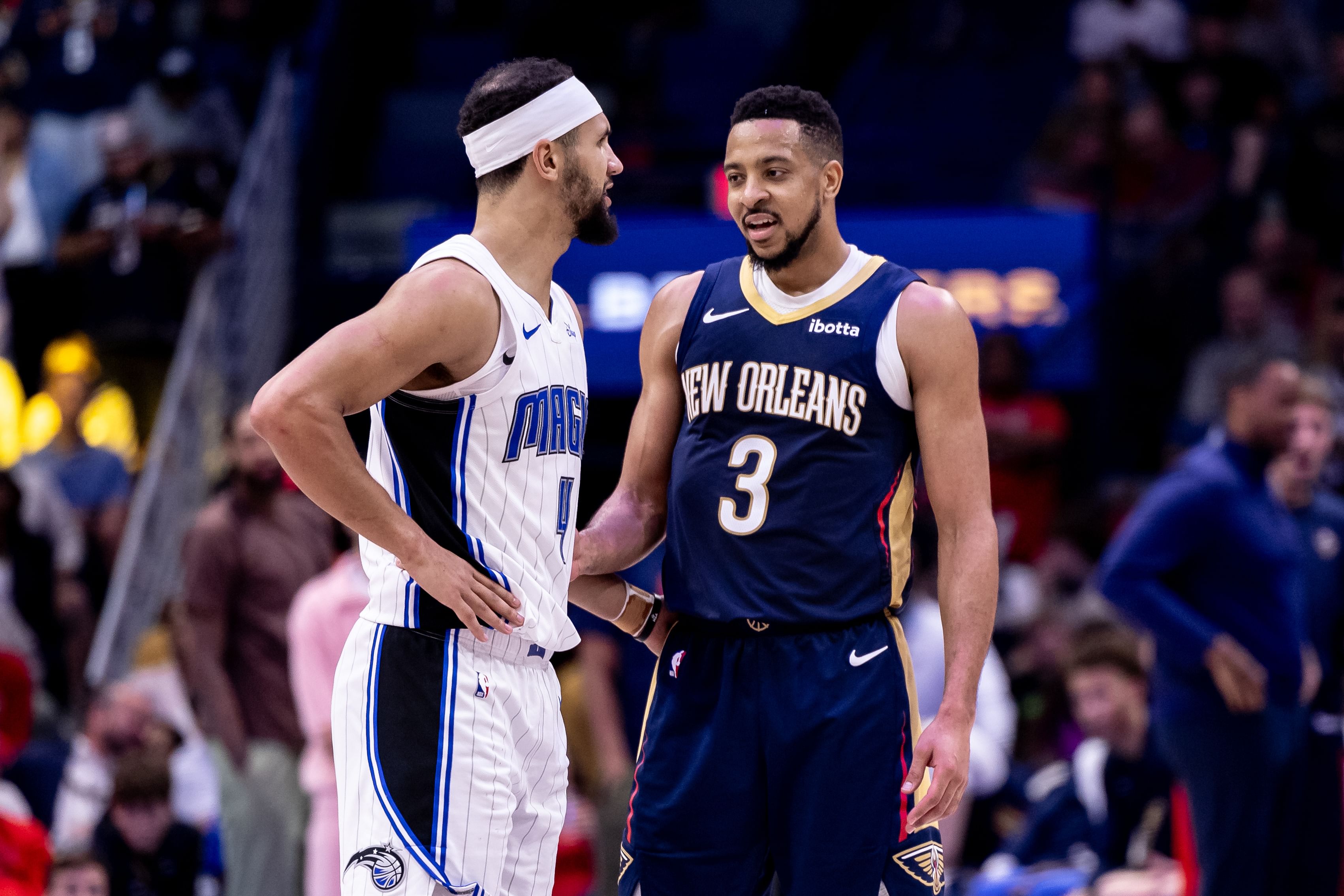 Apr 3, 2024; New Orleans, Louisiana, USA; Orlando Magic guard Jalen Suggs (4) and New Orleans Pelicans guard CJ McCollum (3) talk during a free throw attempt during the second half at Smoothie King Center. Mandatory Credit: Stephen Lew-Imagn Images - Source: Imagn