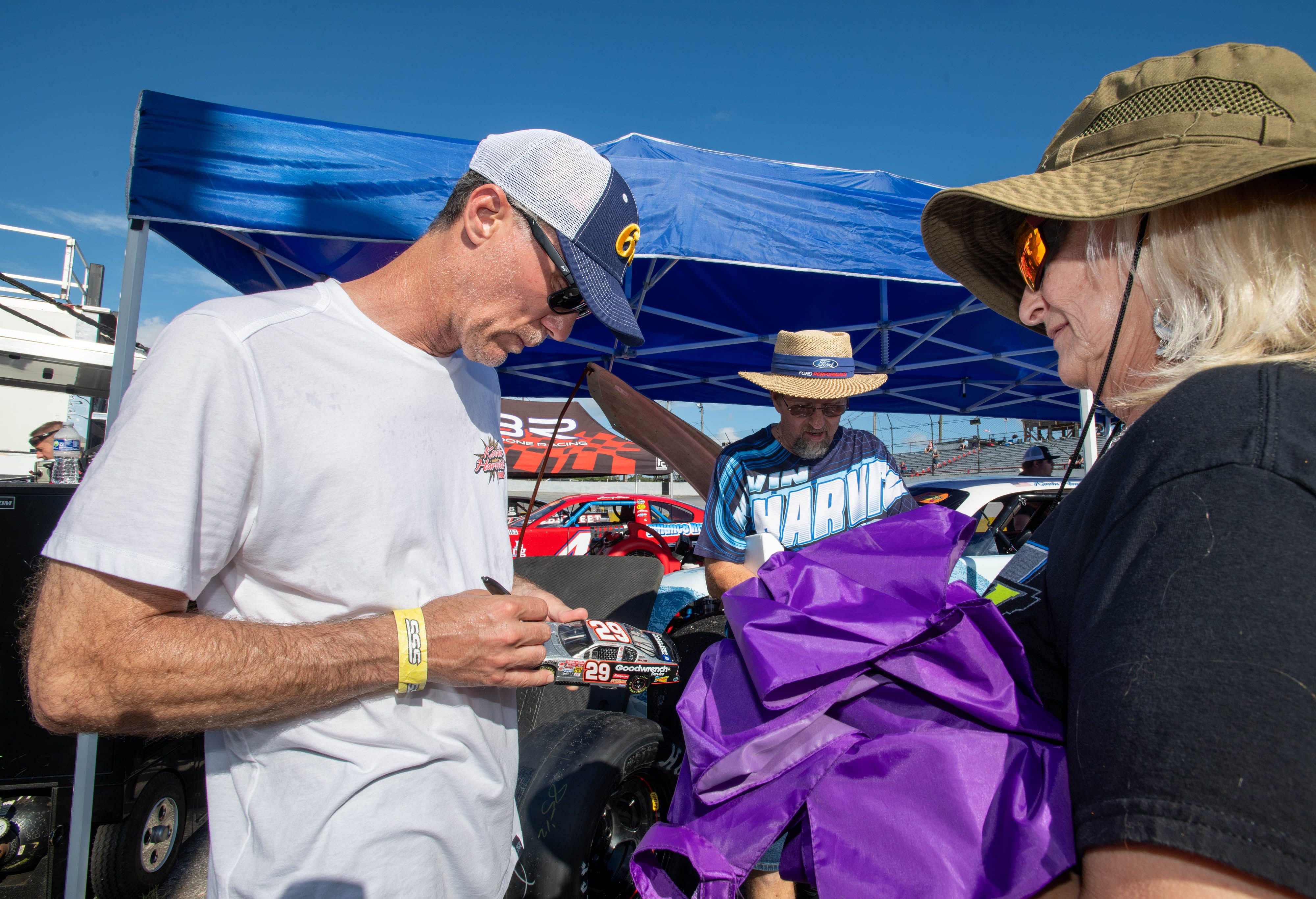 Kevin Harvick signs a diecast car - Source: Imagn