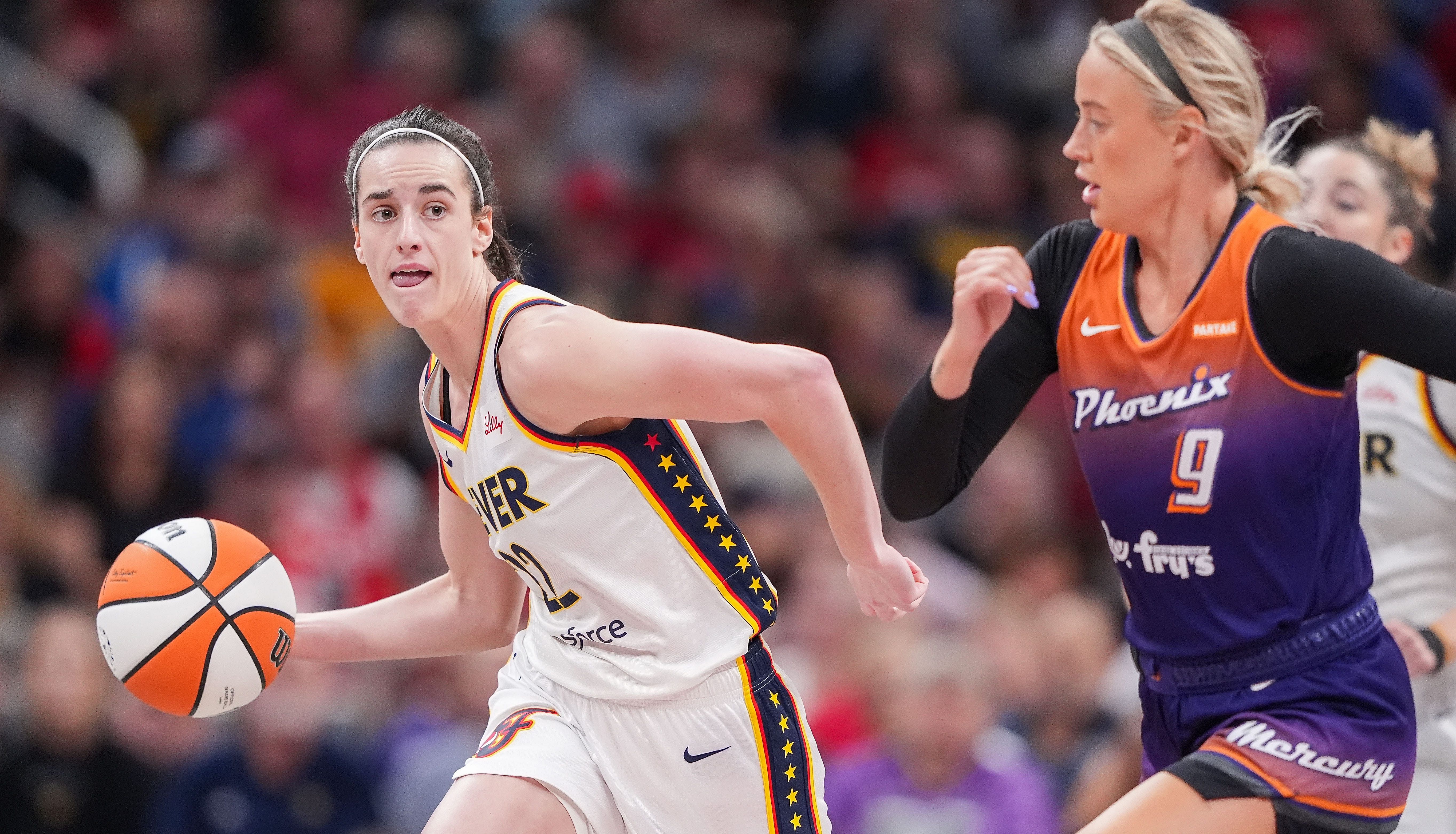 Indiana Fever guard Caitlin Clark rushes up the court against Phoenix Mercury guard Sophie Cunningham at Gainbridge Fieldhouse. (Credits: IMAGN)