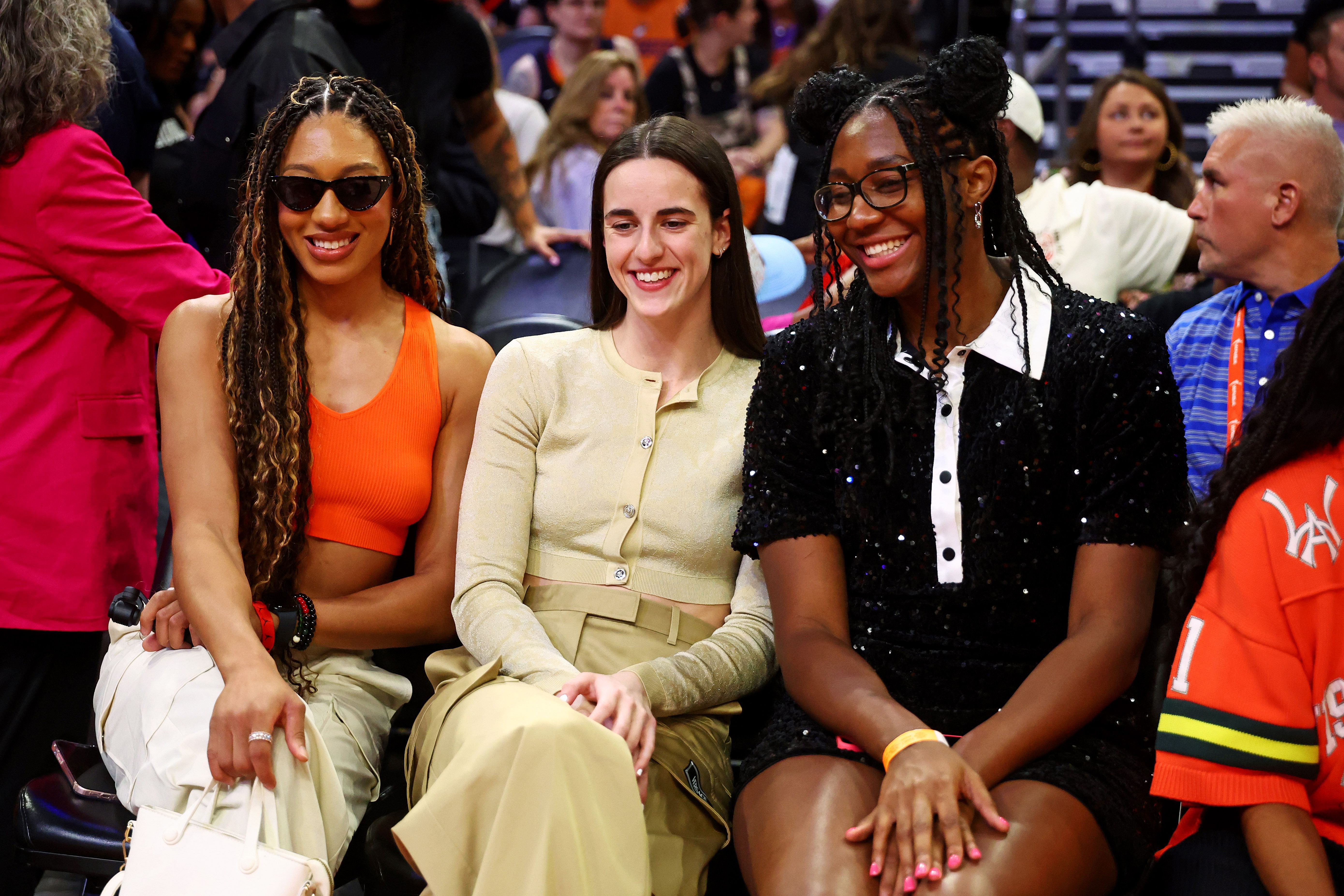 Jul 19, 2024; Phoenix, AZ, USA; WNBA All-stars Aerial Powers, Caitlin Clark and Aliyah Boston look on from the sidelines during the WNBA All-Star Skills Night at the Footprint Center. Mandatory Credit: Mark J. Rebilas-Imagn Images - Source: Imagn