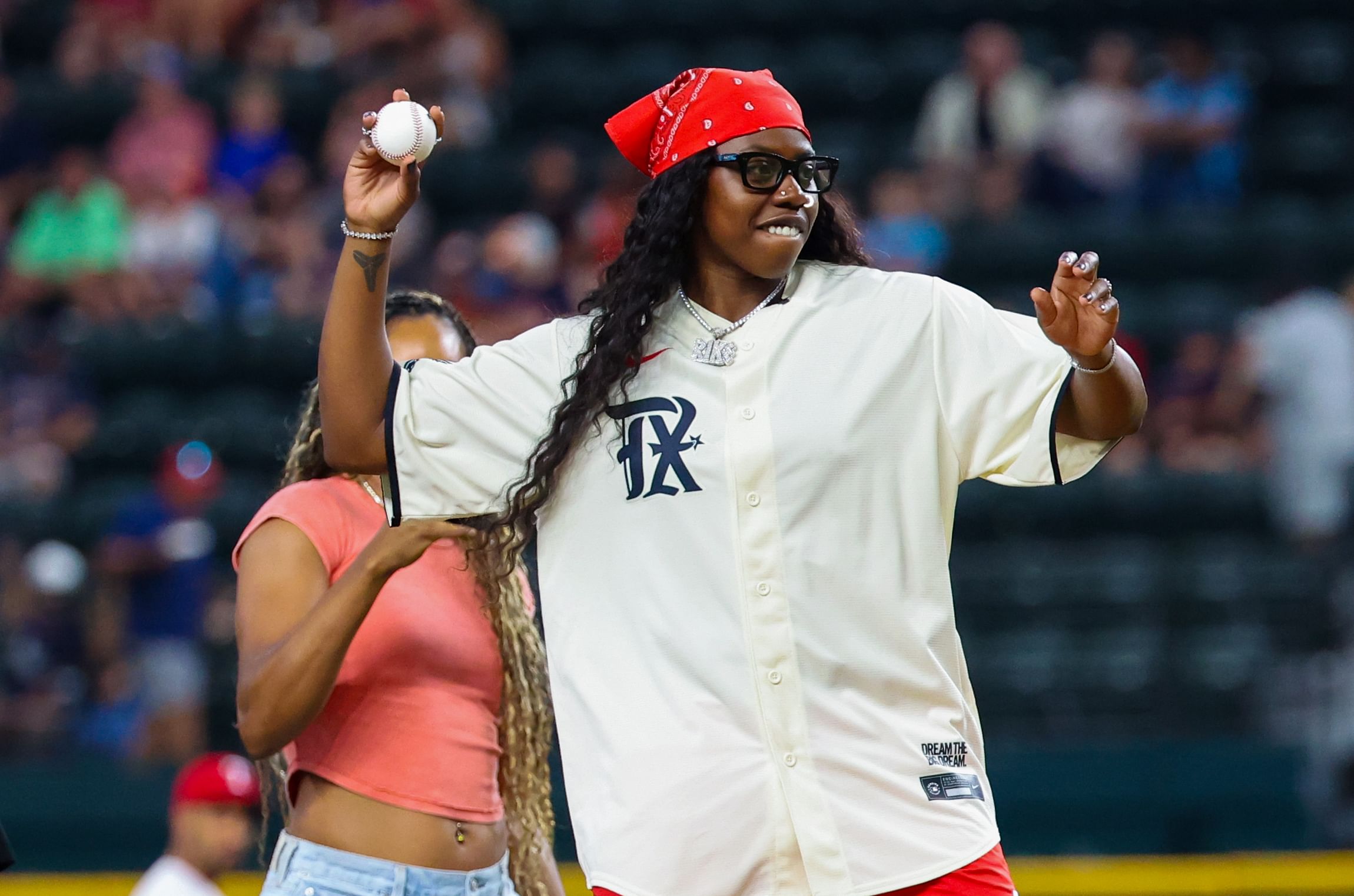 Aug 6, 2024; Arlington, Texas, USA; Dallas Wings player Arike Ogunbowale throws out the first pitch before the game between the Texas Rangers and Houston Astros at Globe Life Field. Mandatory Credit: Kevin Jairaj-Imagn Images - Source: Imagn