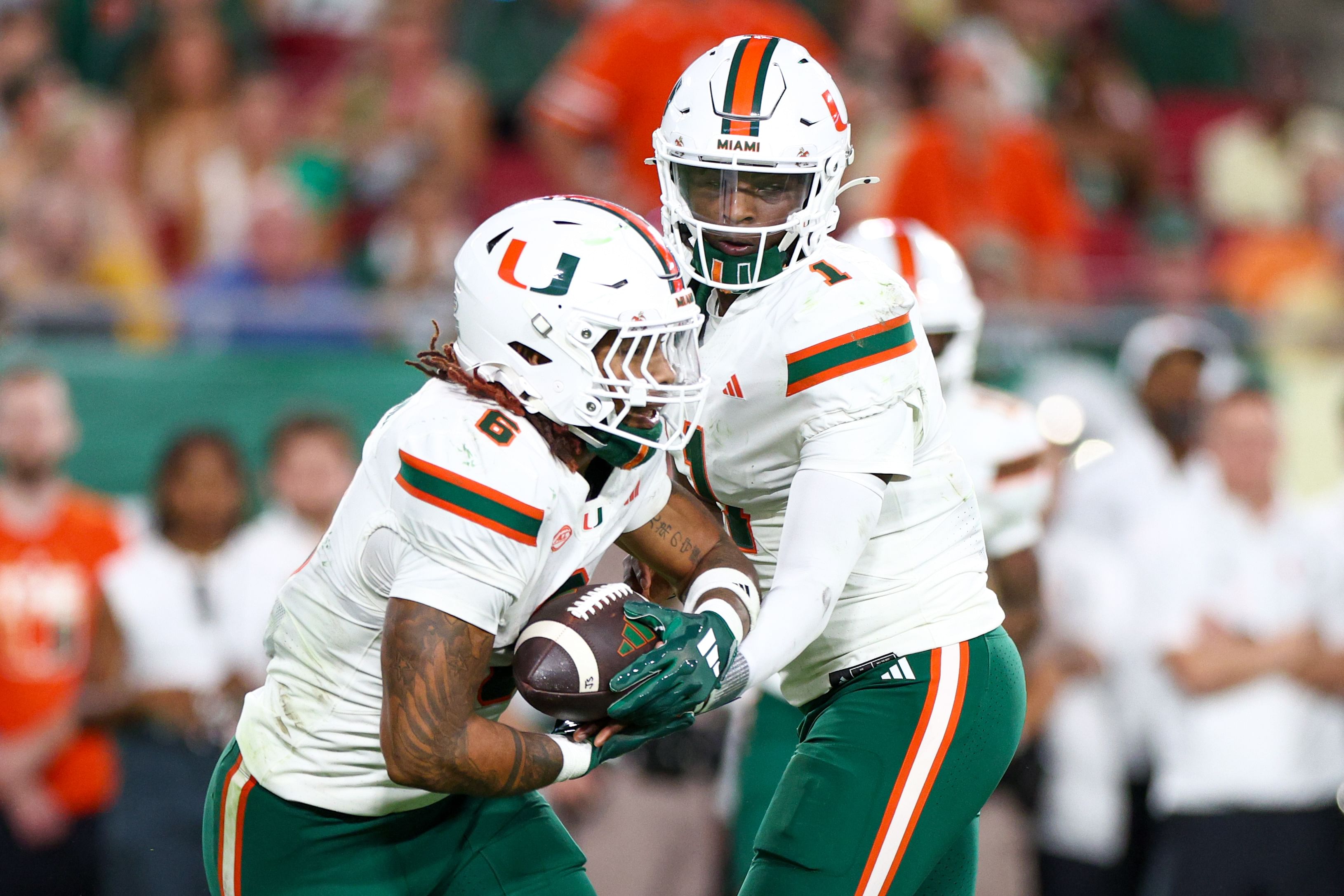 NCAA Football: Miami QB Cam Ward hands off to RB Damien Martinez - Source: Imagn