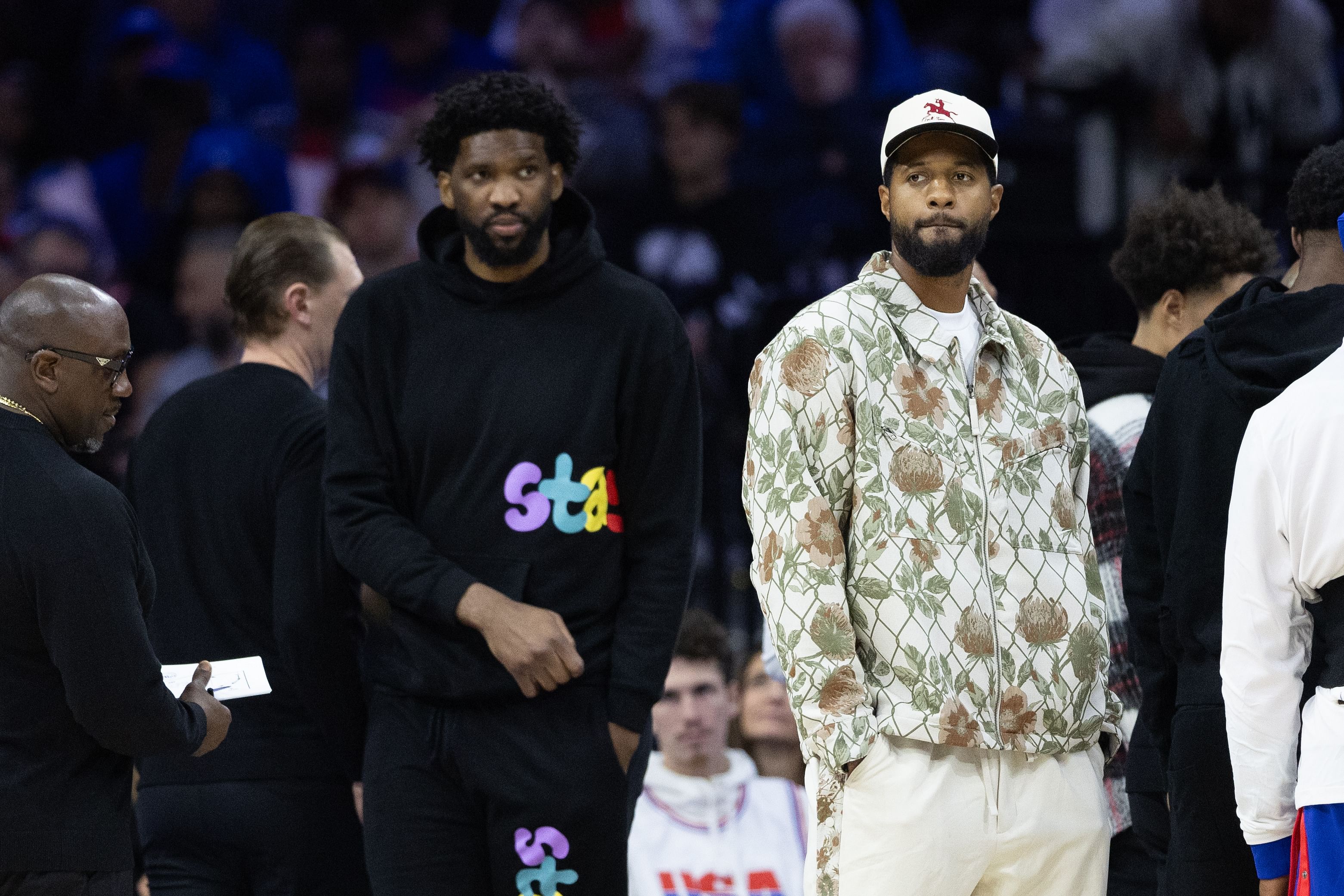 Nov 2, 2024; Philadelphia, Pennsylvania, USA; Injured Philadelphia 76ers Paul George (R) and Joel Embiid (L) look on during the first quarter against the Memphis Grizzlies at Wells Fargo Center. Mandatory Credit: Bill Streicher-Imagn Images - Source: Imagn