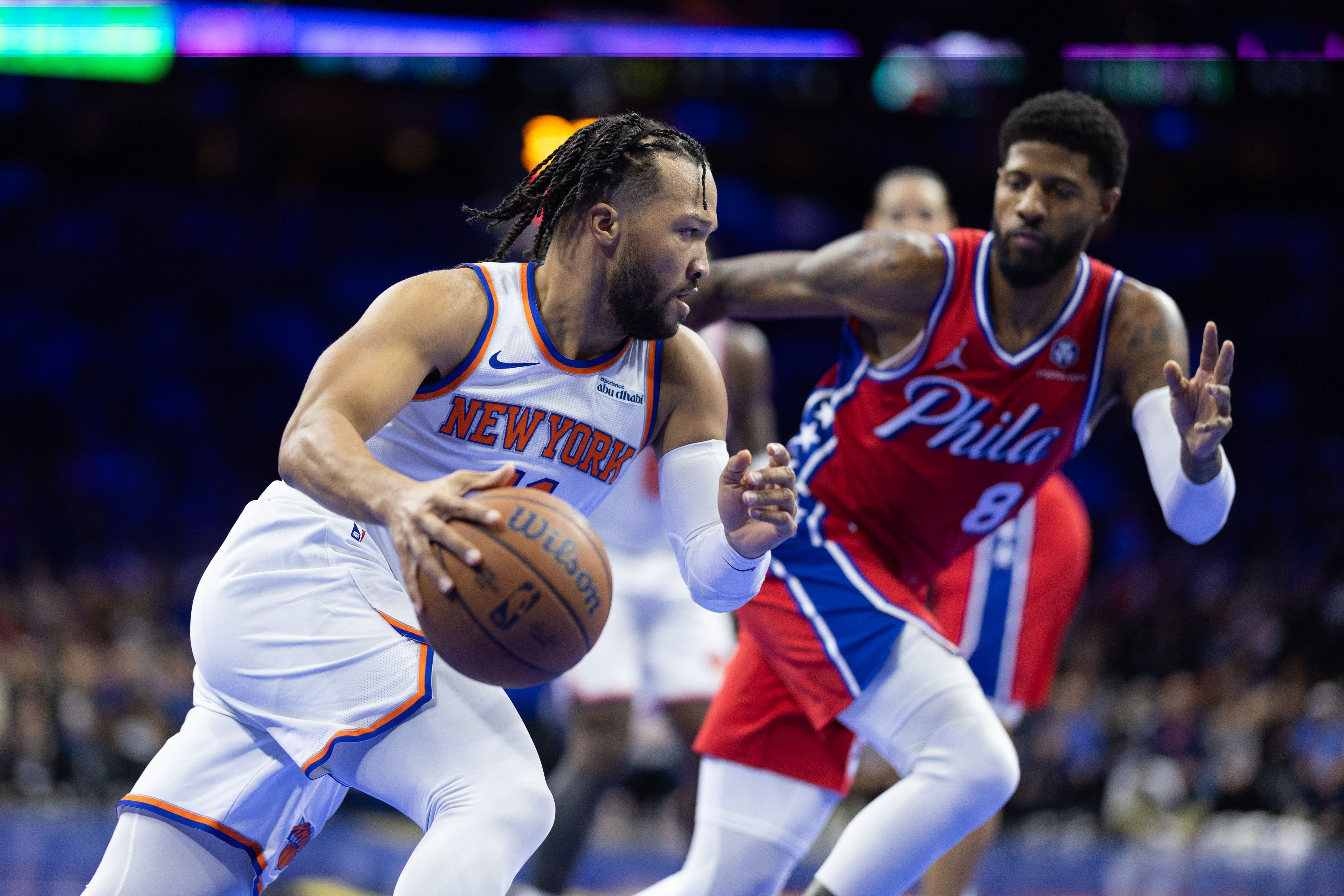 Nov 12, 2024; Philadelphia, Pennsylvania, USA; New York Knicks guard Jalen Brunson (11) drives in front of Philadelphia 76ers forward Paul George (8) during the second quarter at Wells Fargo Center. Mandatory Credit: Bill Streicher-Imagn Images - Source: Imagn