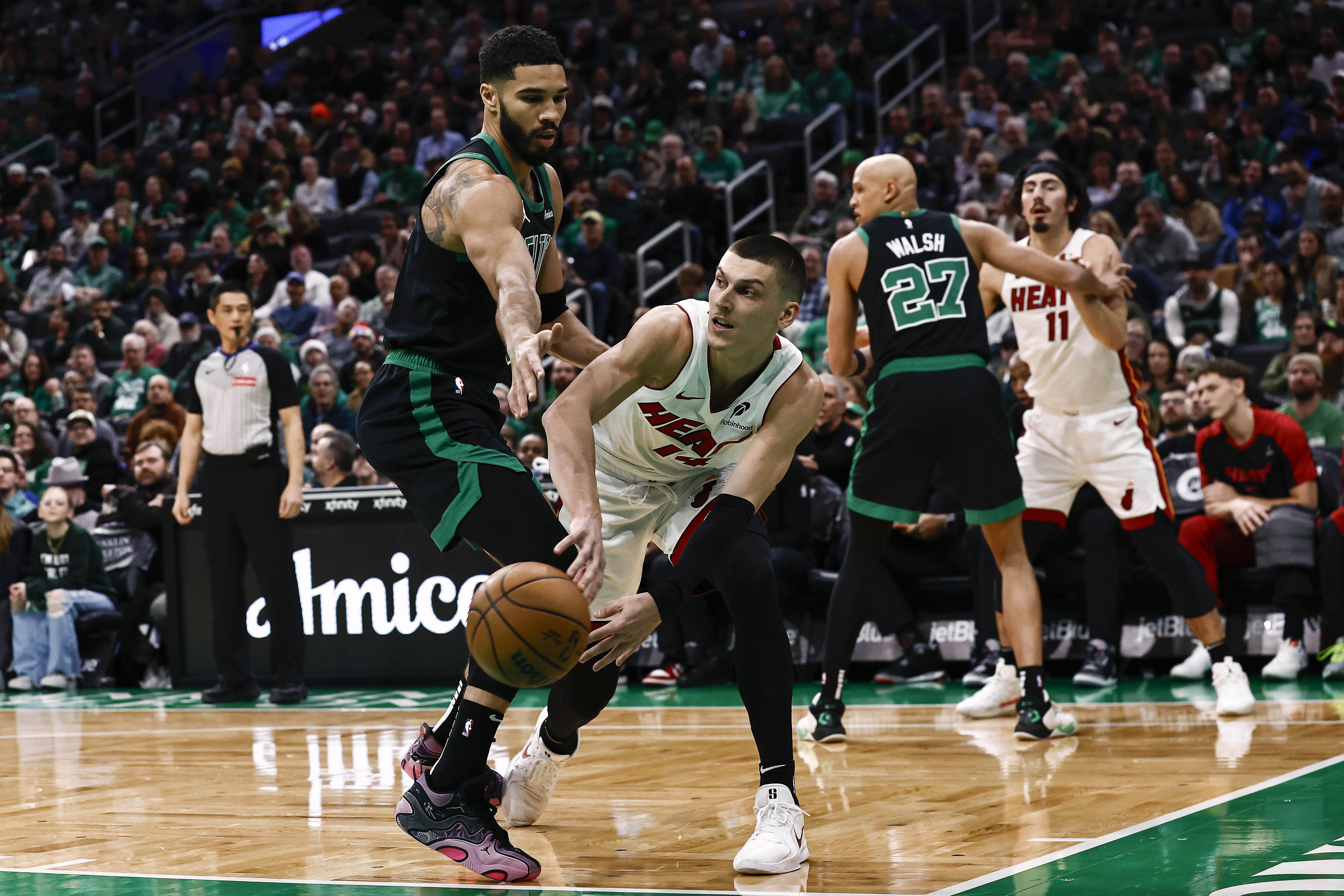 Miami Heat guard Tyler Herro passes around Boston Celtics forward Jayson Tatum at TD Garden. Photo Credit: Imagn