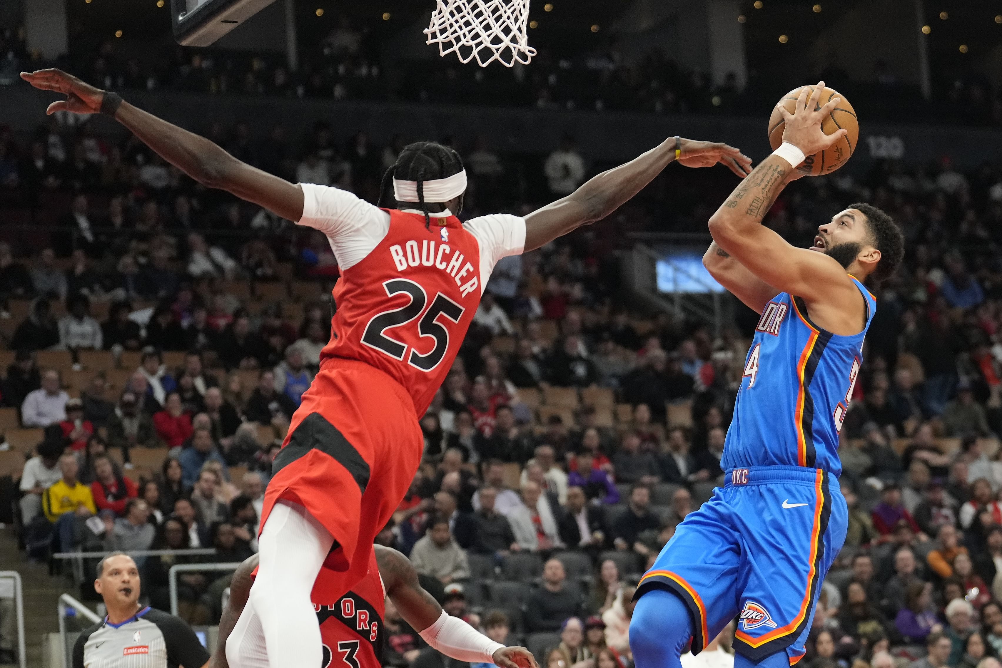 Dec 5, 2024; Toronto, Ontario, CAN; Oklahoma City Thunder forward Kenrich Williams (34) shoots a basket as Toronto Raptors forward Chris Boucher (25) defends during the second half at Scotiabank Arena. Mandatory Credit: John E. Sokolowski-Imagn Images - Source: Imagn