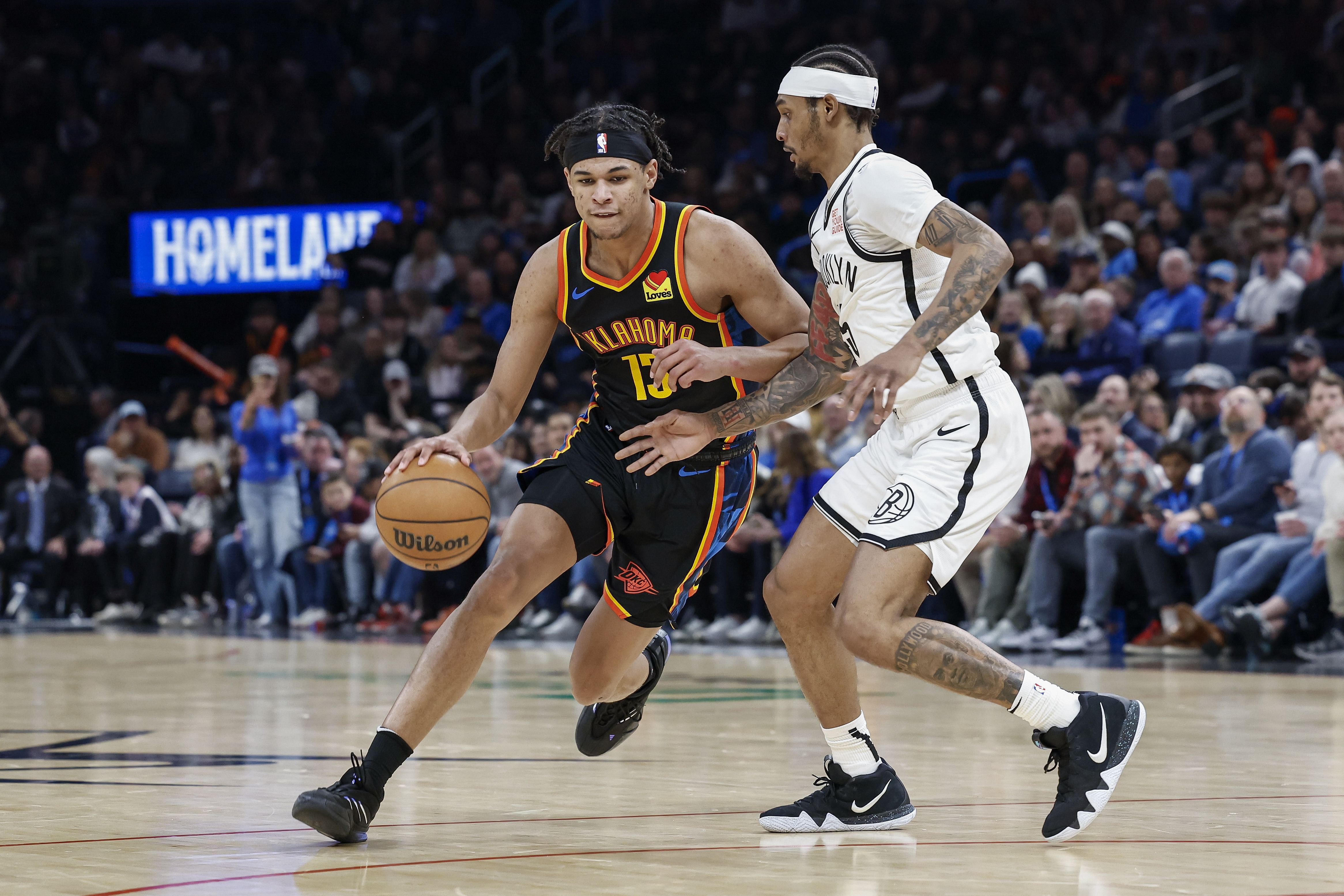 Jan 19, 2025; Oklahoma City, Oklahoma, USA; Oklahoma City Thunder forward Ousmane Dieng (13) drives around Brooklyn Nets guard Keon Johnson (45) during the second half at Paycom Center. Mandatory Credit: Alonzo Adams-Imagn Images - Source: Imagn