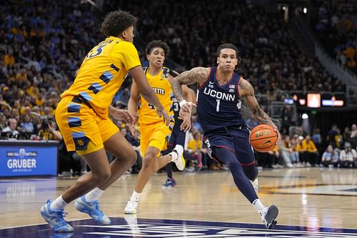 UConn Huskies guard Solo Ball (#1) attacks the defense of Marquette Golden Eagles forward Royce Parham (#13) during the first half at Fiserv Forum. Photo: Imagn