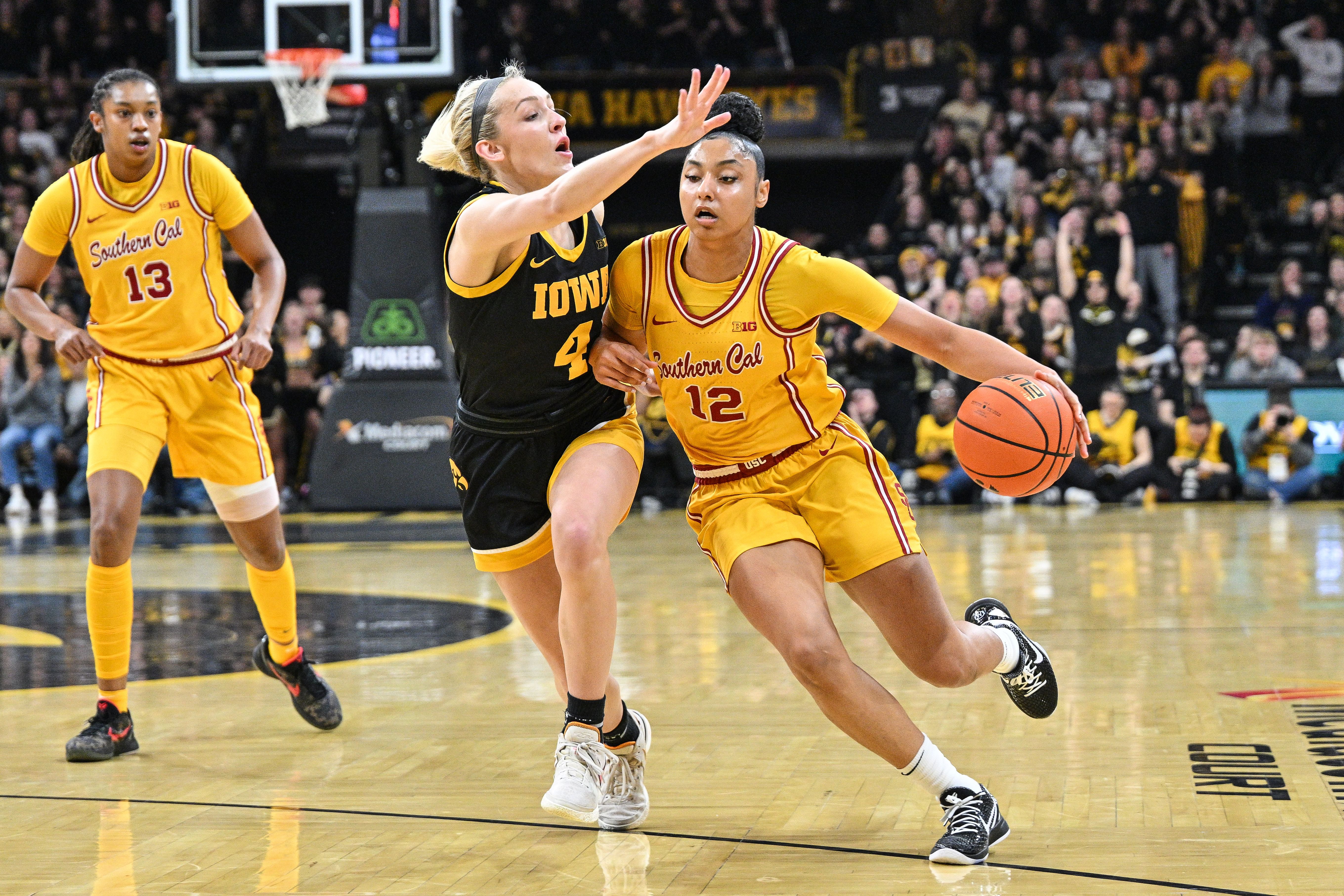 USC Trojans star JuJu Watkins (#12) attacks the defense of Iowa Hawkeyes guard Kylie Feuerbach (#4) during the first quarter at Carver-Hawkeye Arena. Photo: Imagn