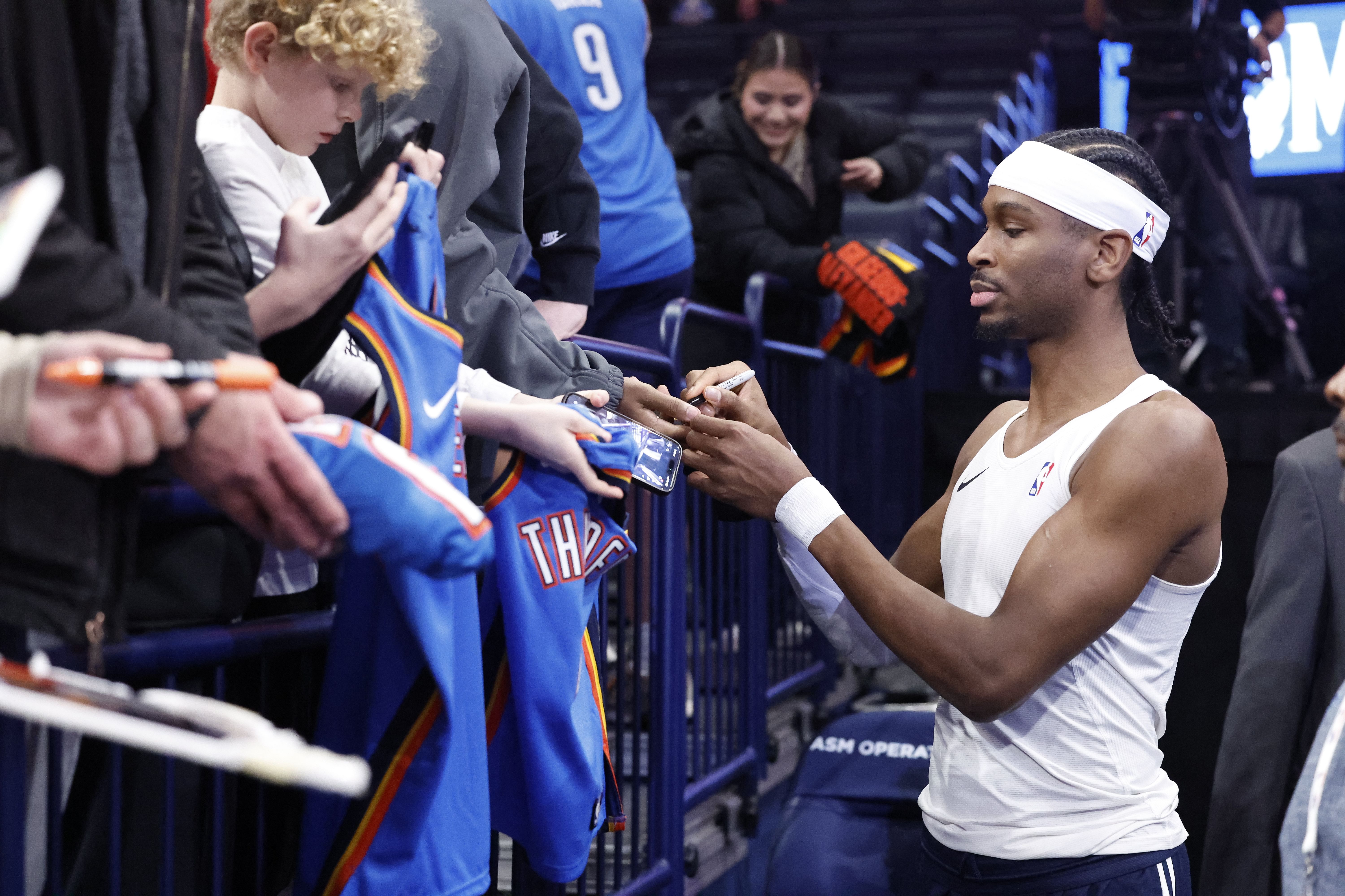 Feb 5, 2025; Oklahoma City, Oklahoma, USA; Oklahoma City Thunder guard Shai Gilgeous-Alexander (2) signs autographs before the start of a game against the Phoenix Suns at Paycom Center. Mandatory Credit: Alonzo Adams-Imagn Images - Source: Imagn