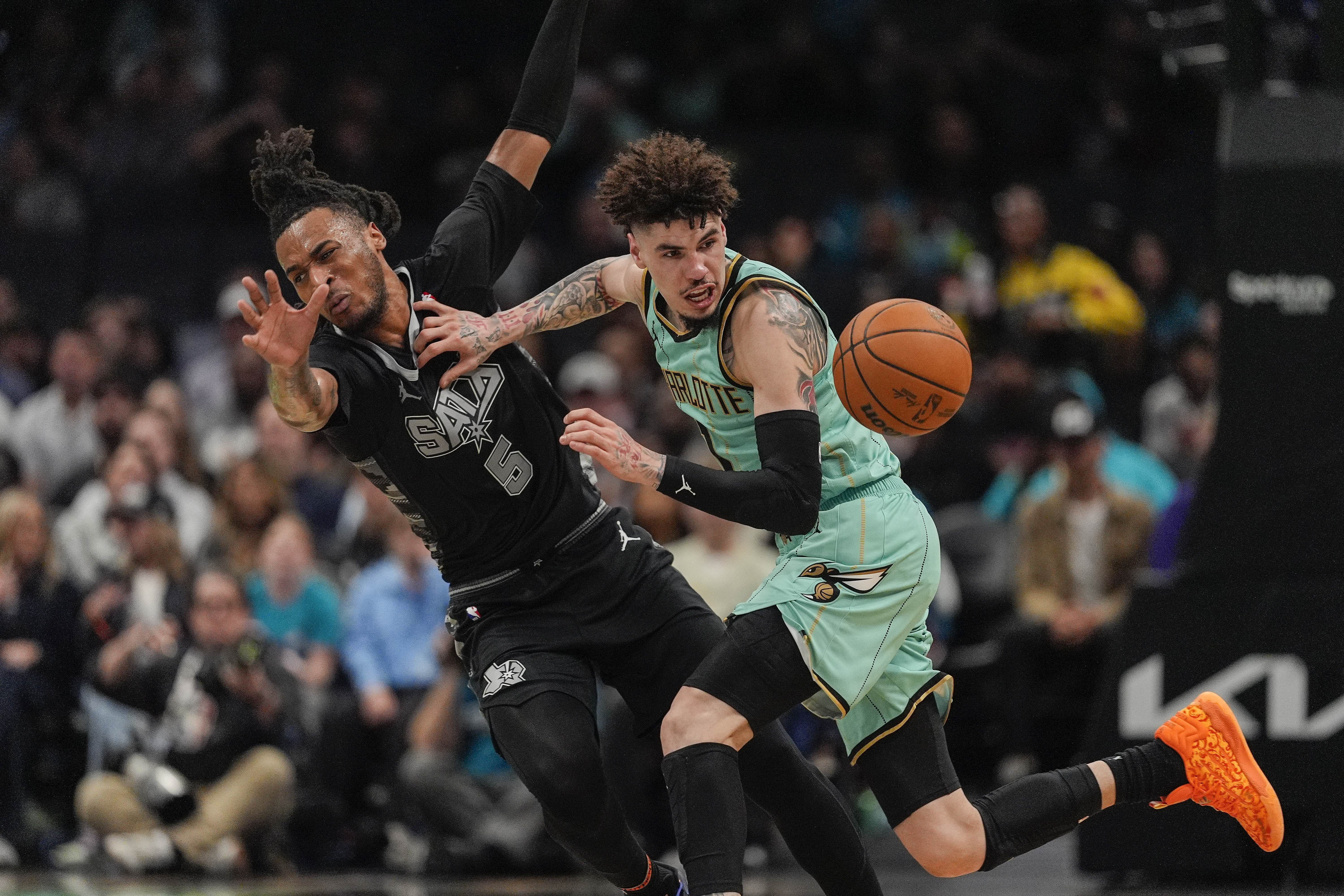 Feb 7, 2025; Charlotte, North Carolina, USA; Charlotte Hornets guard LaMelo Ball (1) fouls San Antonio Spurs guard Stephon Castle (5) going for the loose ball during the second half at Spectrum Center. Mandatory Credit: Jim Dedmon-Imagn Images - Source: Imagn