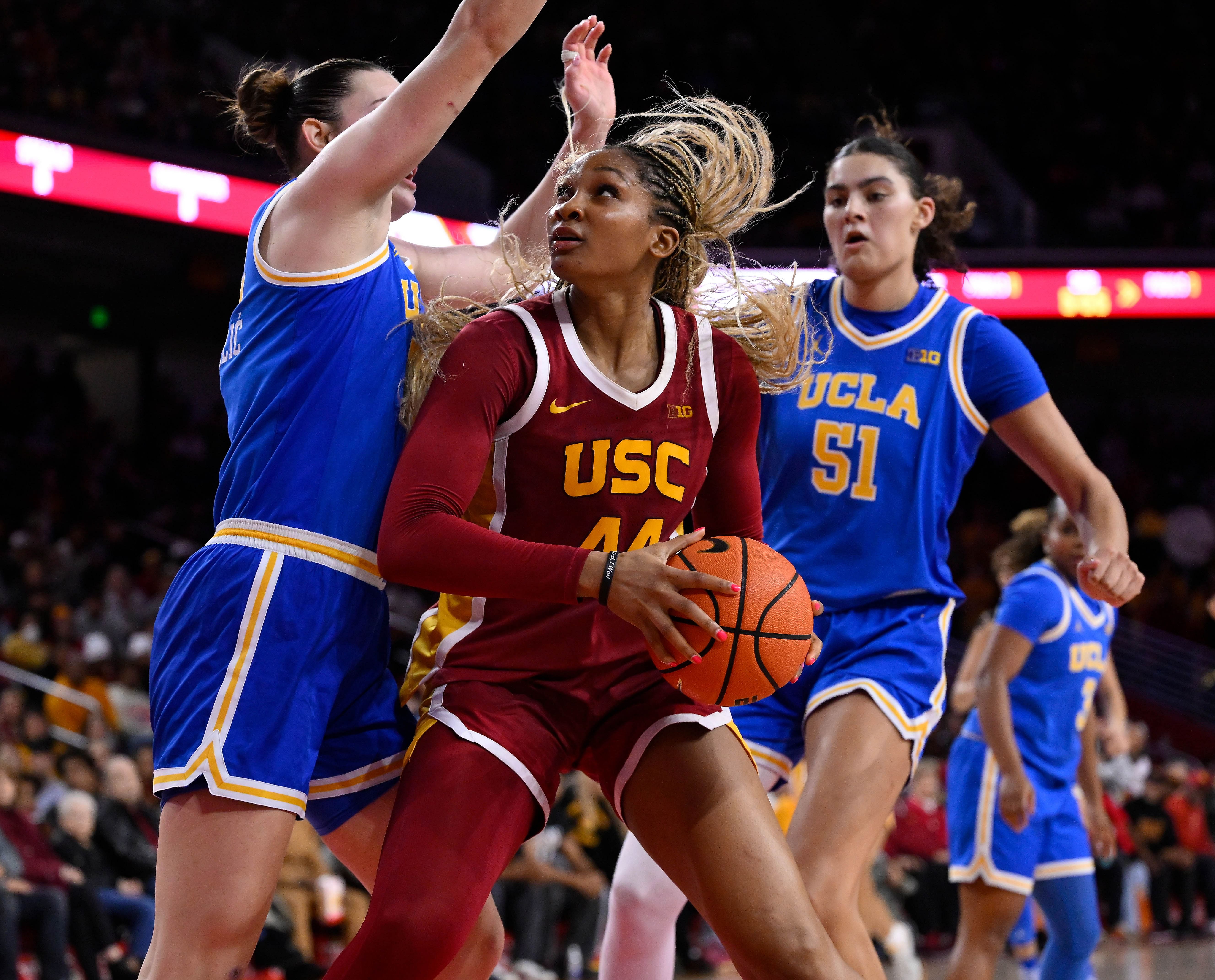 USC Trojans forward Kiki Iriafen (#44) tries to score between UCLA Bruins forward Angela Dugalic (32) and center Lauren Betts (51) during their game at Galen Center. Photo: Imagn